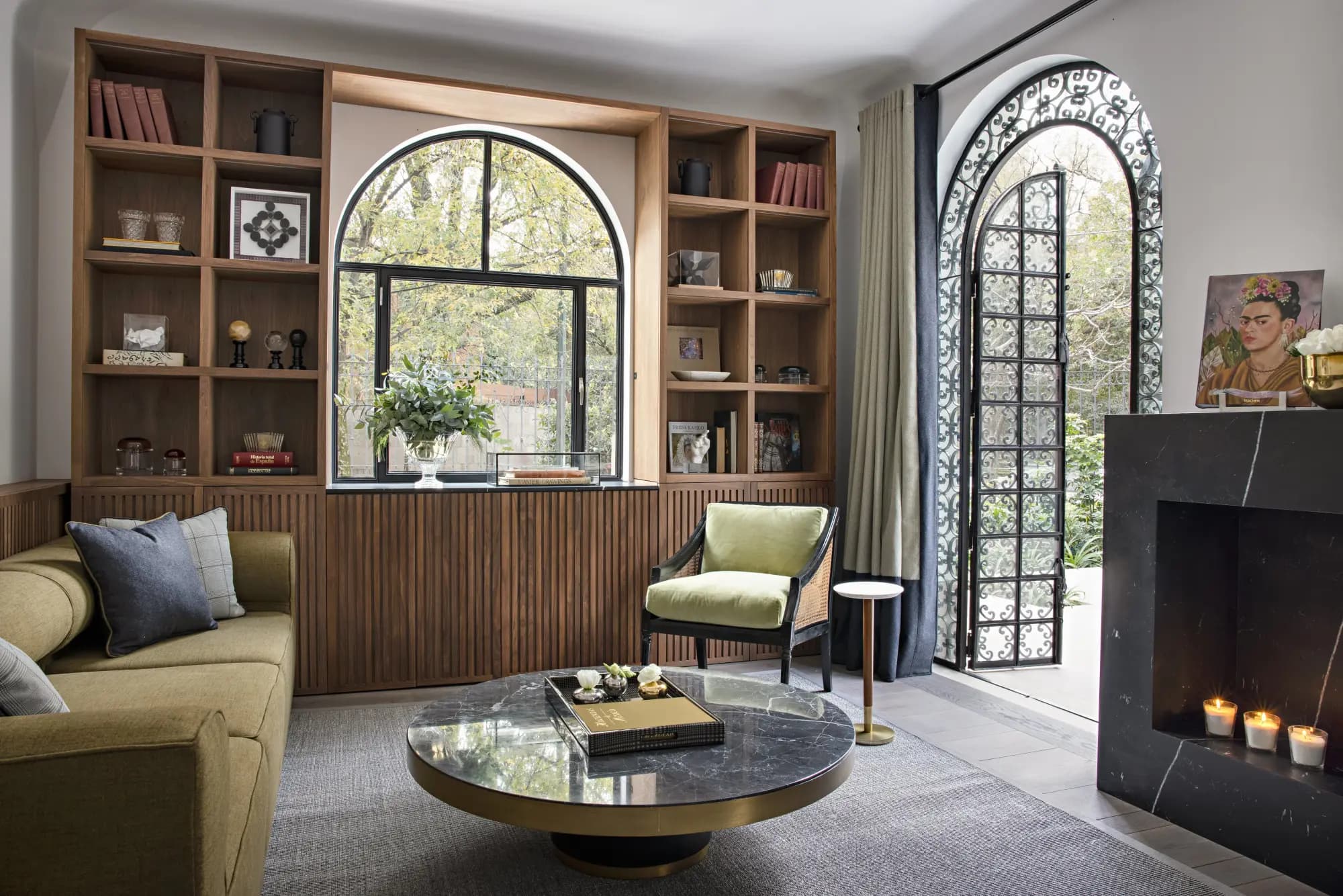 a stylish living room with a green L-shaped couch and a circular marble table