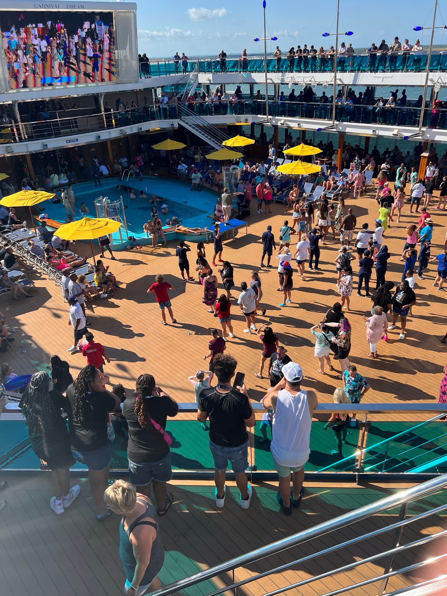 A large group of people scattered around a swimming pool area