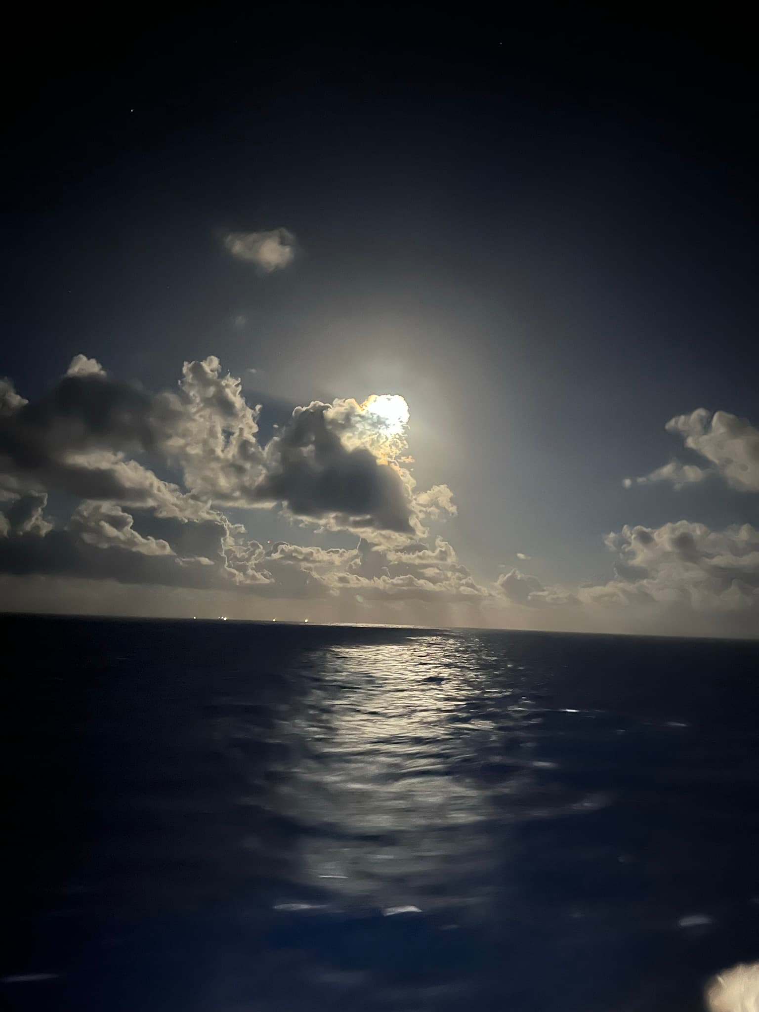 Nighttime view of the water from the back of a ship