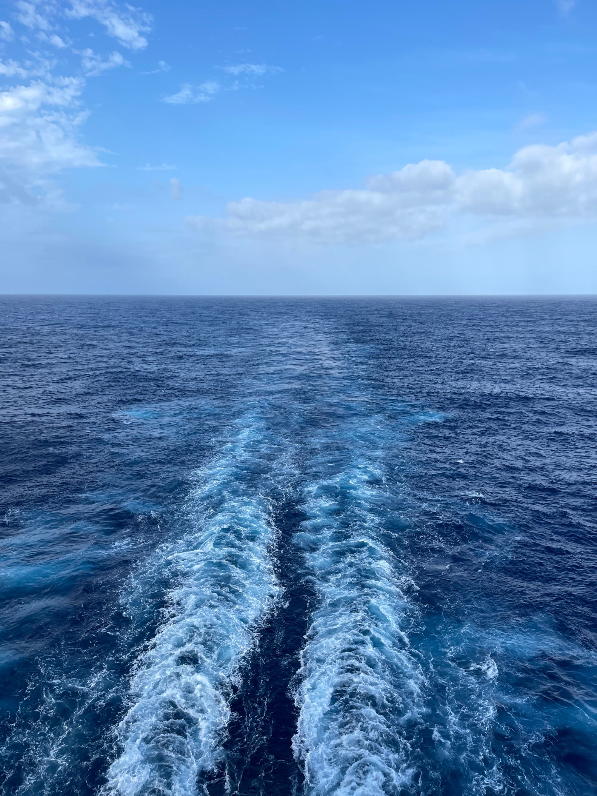 A view o sea and sky from the back end of the ship.