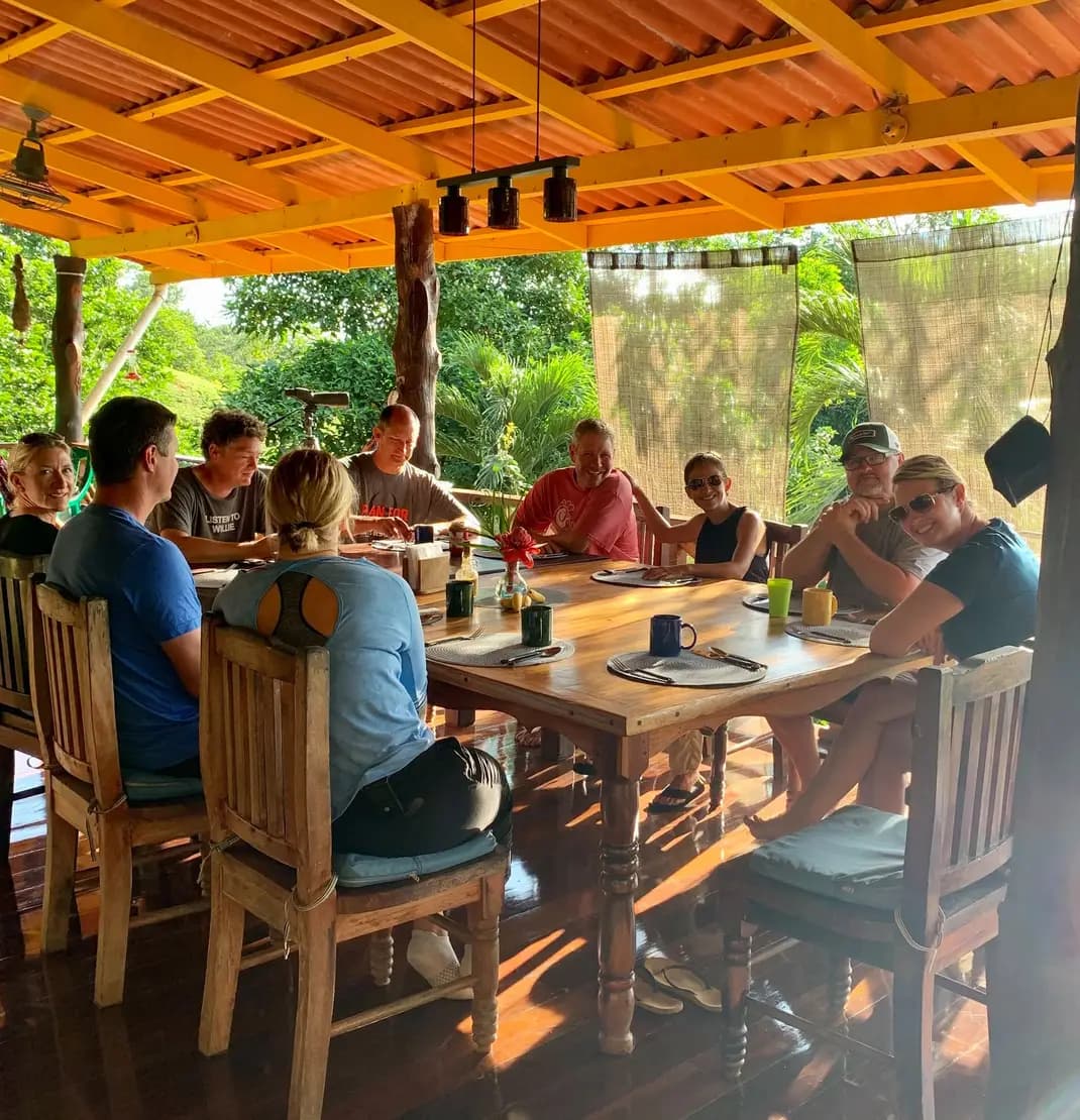 Group of people eating at a table in an outside dining area