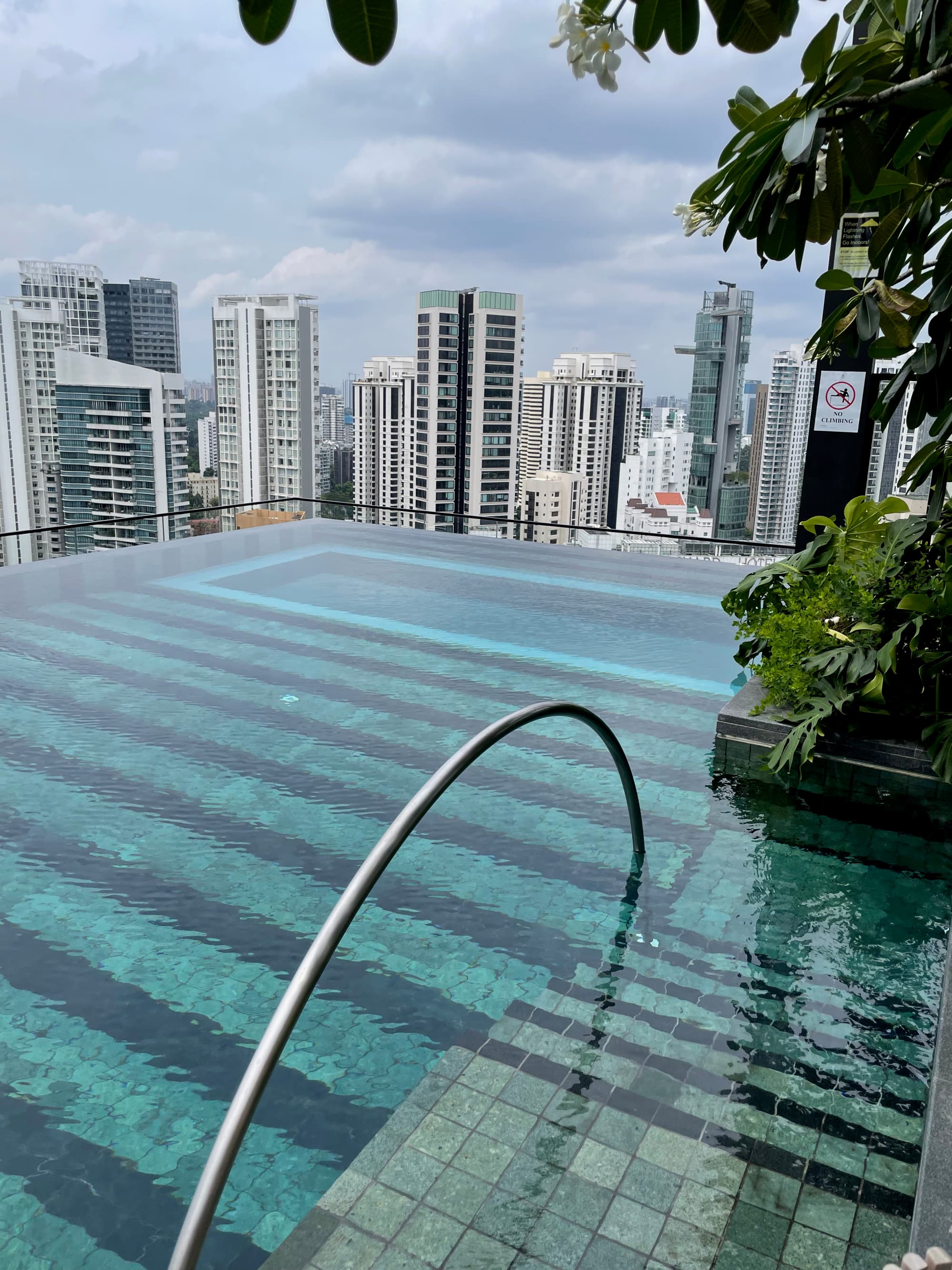 A rooftop pool up high above the city with skyscapers in view