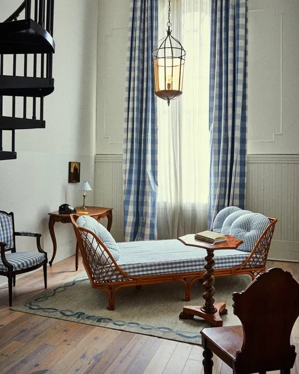 Image 2: A lounge area, day bed, floor-to-ceiling window and curtains, wooden chairs, and a spiral staircase.