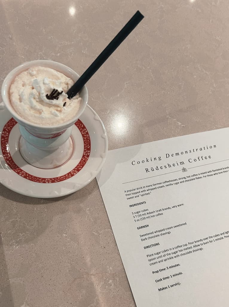 A cup of coffee on a table next to a menu