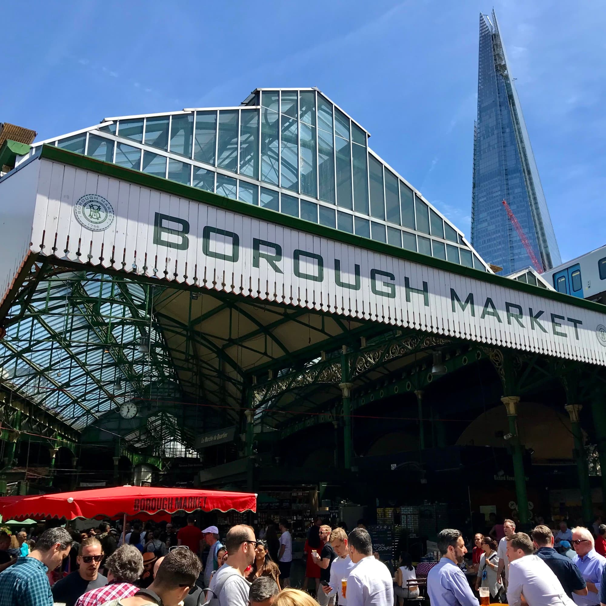 A view of the Borough Market exterior with a tall skyscraper in the background.