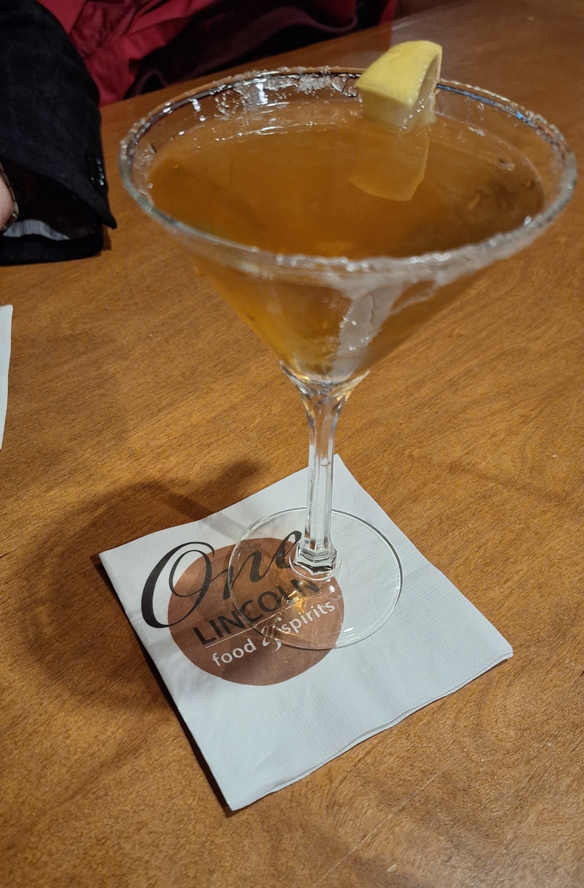 A cocktail in a martini glass sitting on a white napkin