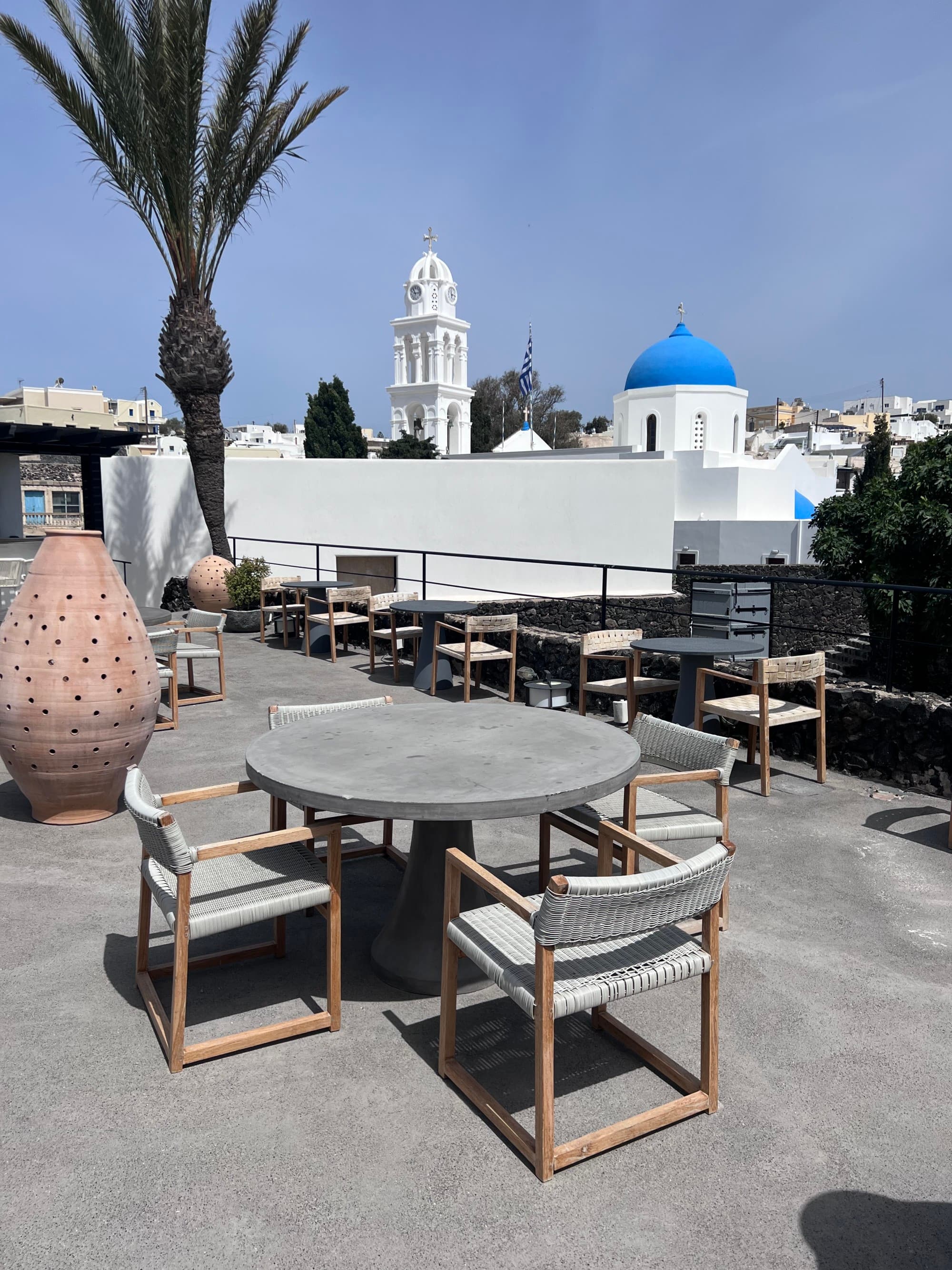 gray table and chairs on a balcony overlooking a white tower