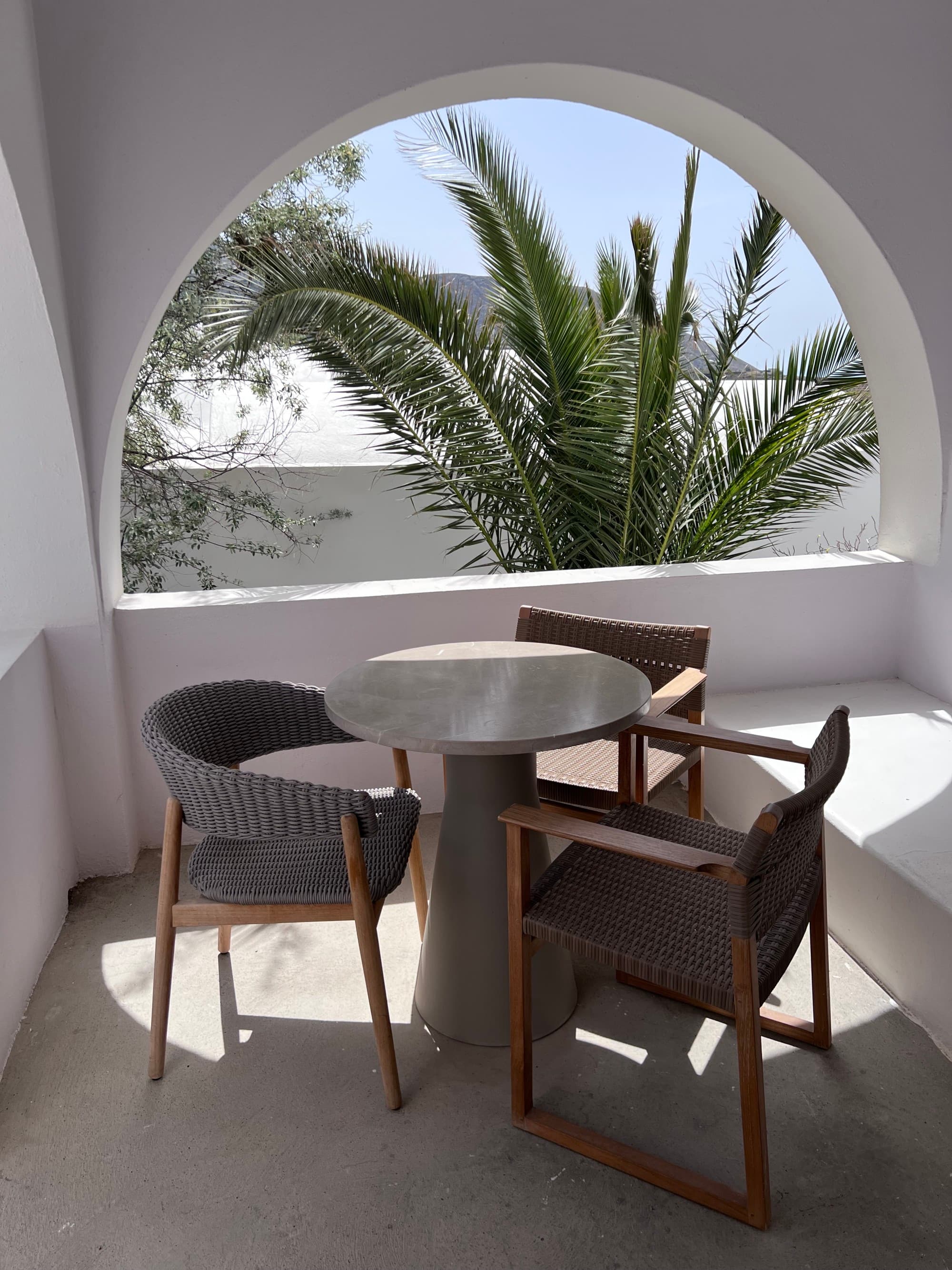 small table and chairs on a white terrace