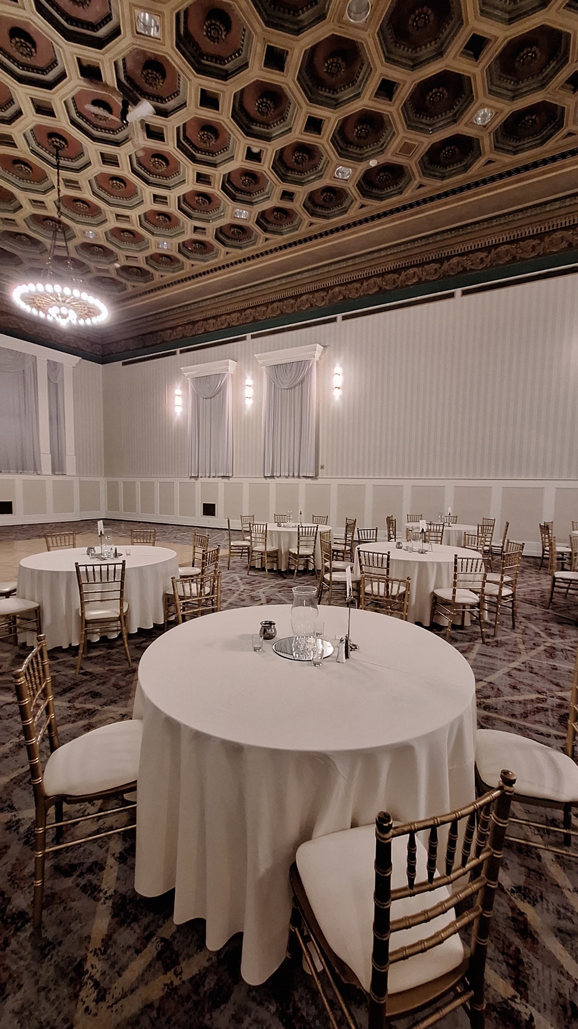 A large dining room with a round, white tables