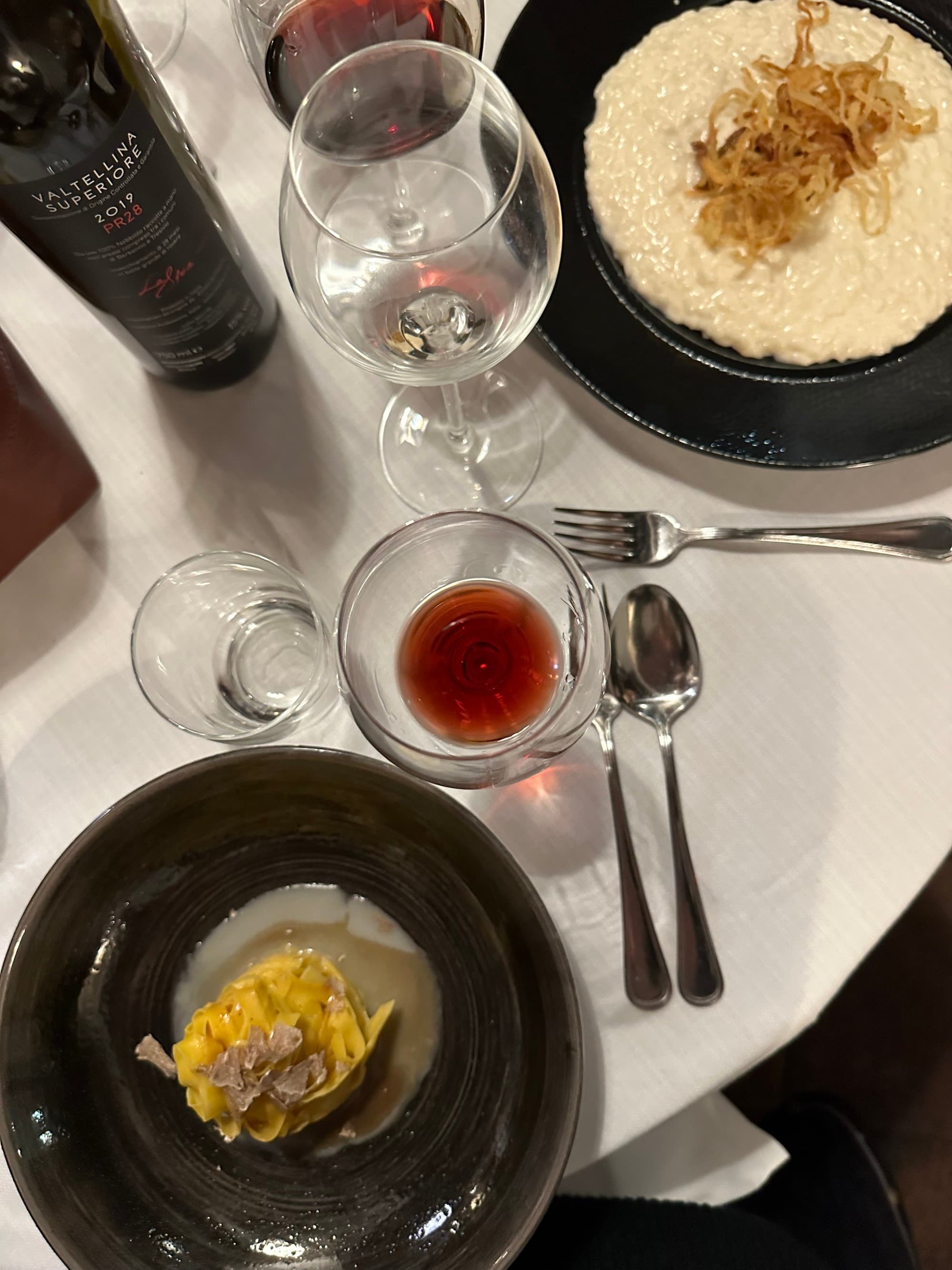 Plates of food on a table with wine glasses