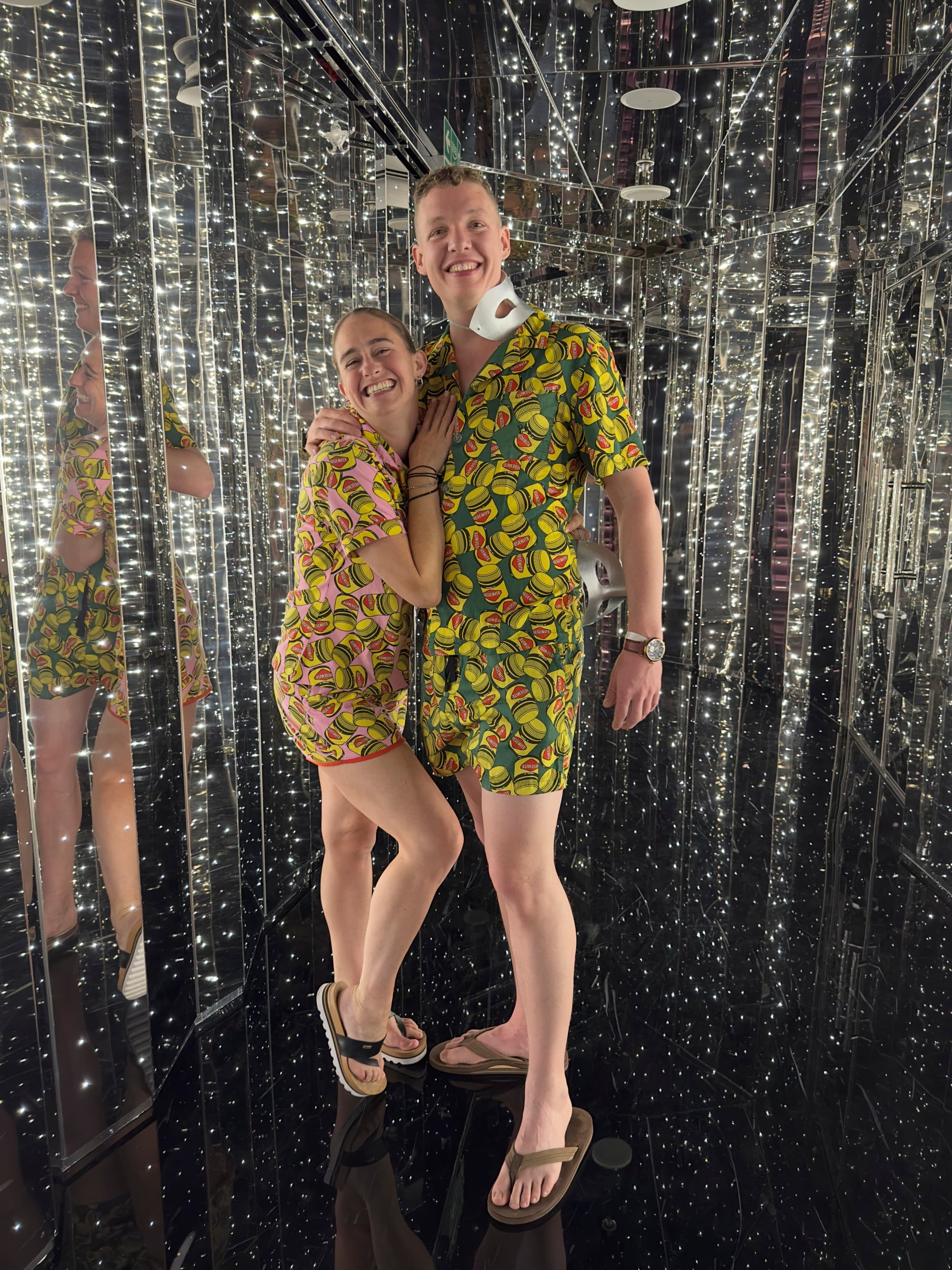 A couple posing in front of a sparkly backdrop