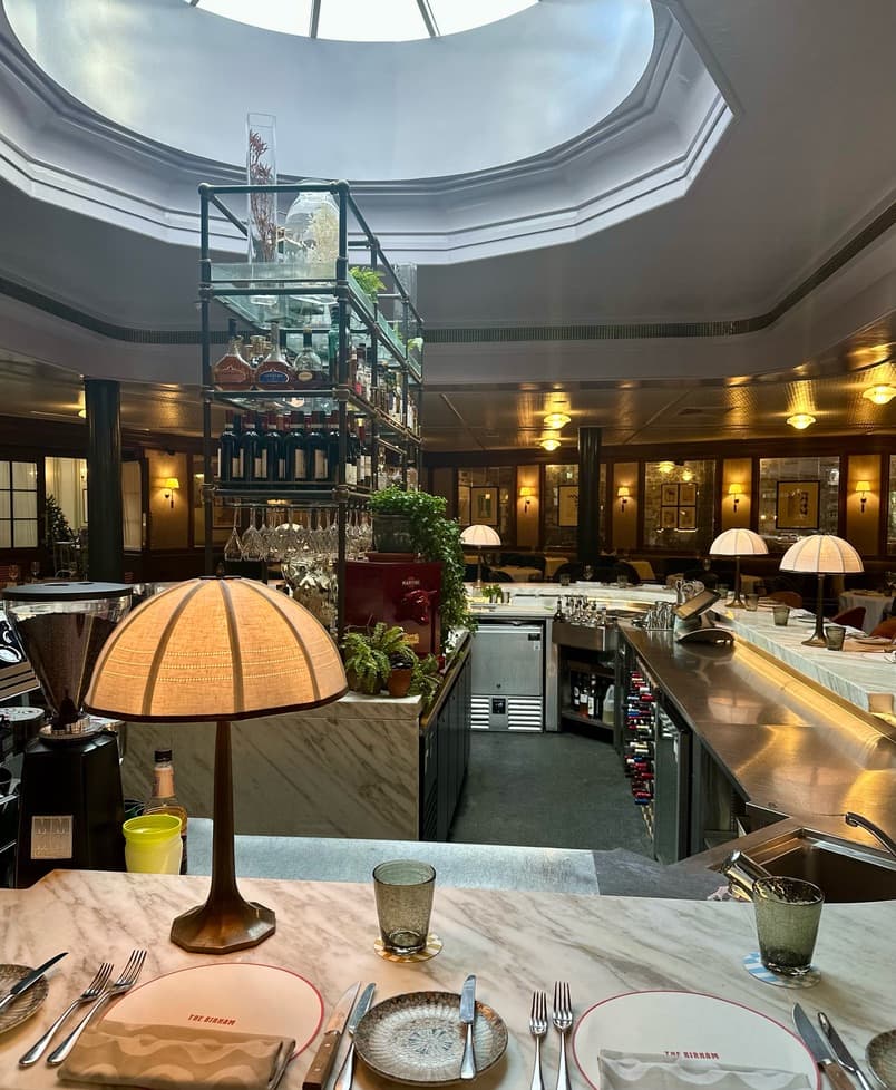 Inside dining area with a circular sky light and lovely decor.