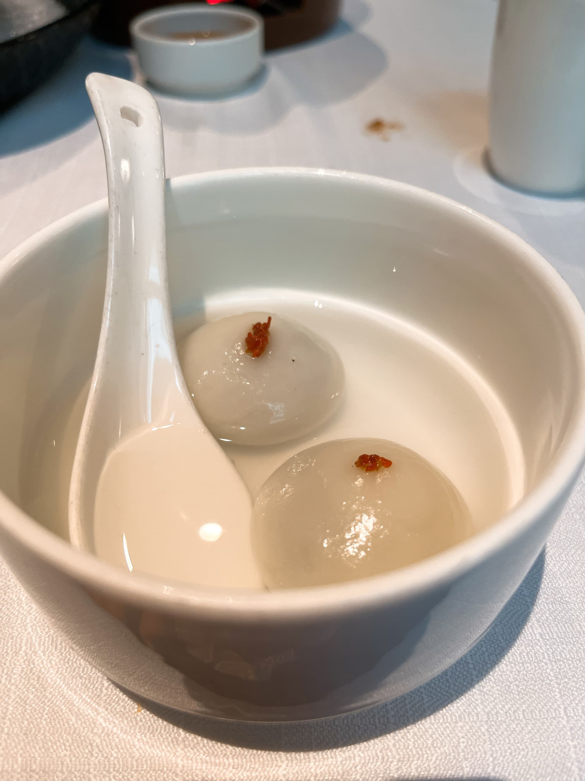 Two balls in a ceramic bowl bowl with soup spoon