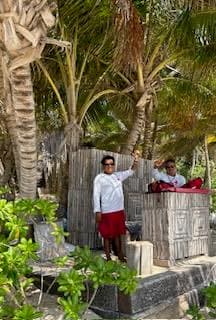 A picture of two lifeguards at the hotel standing on a stone platform dressed in white and red