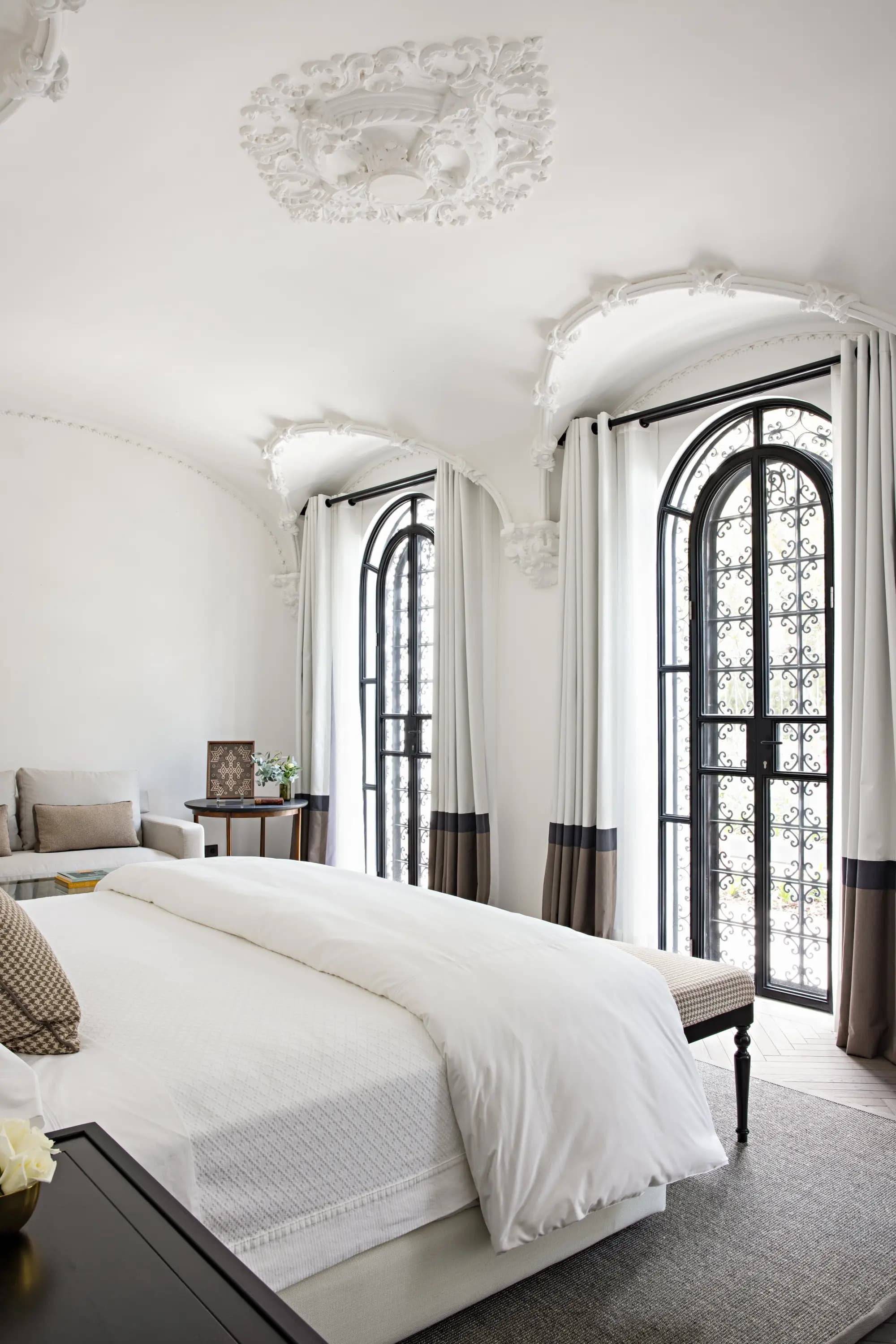 a luxe hotel room with floor-to-ceiling windows flanked by drapes