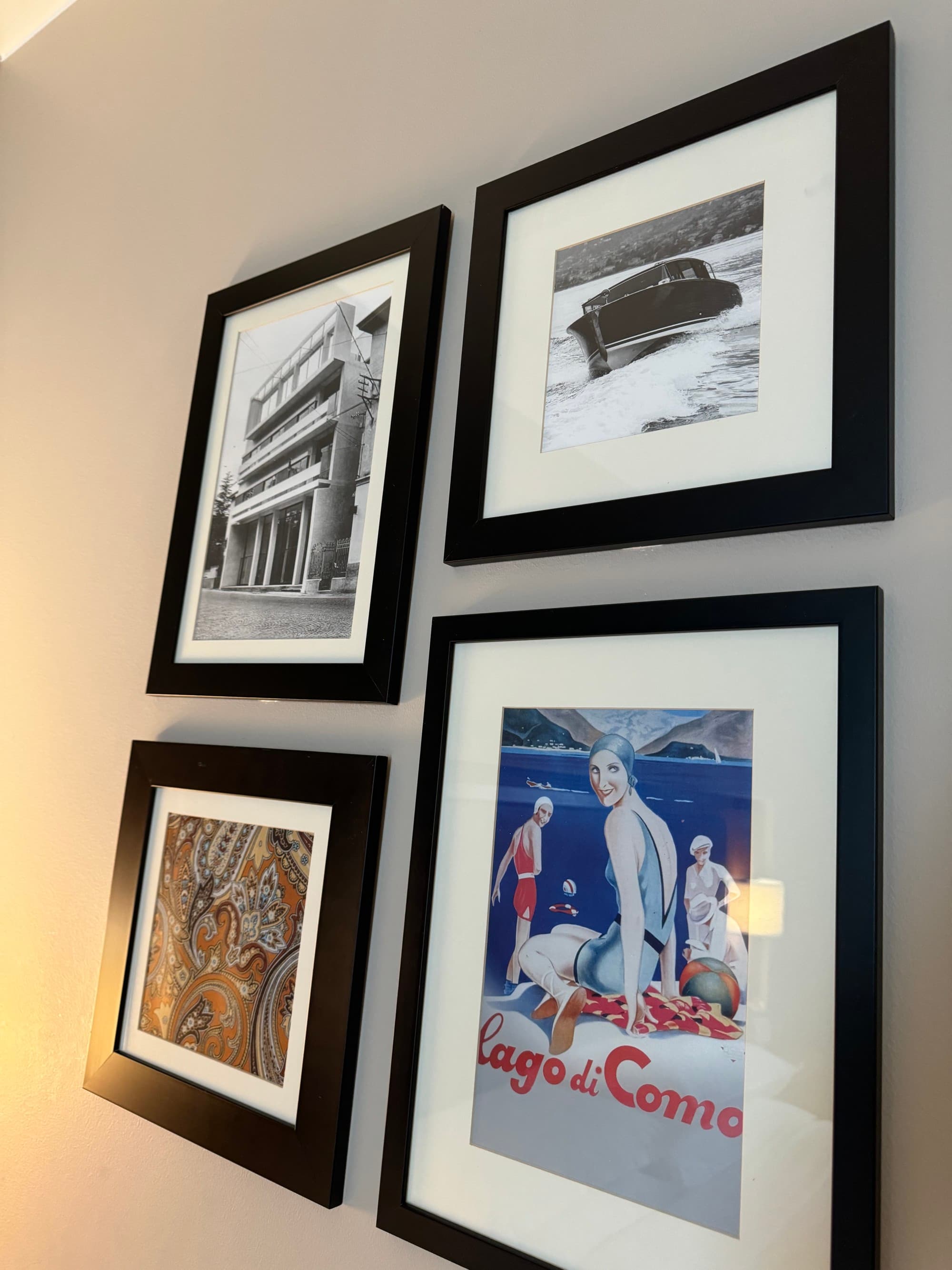 Four, small framed vintage posters hanging on a wall together.