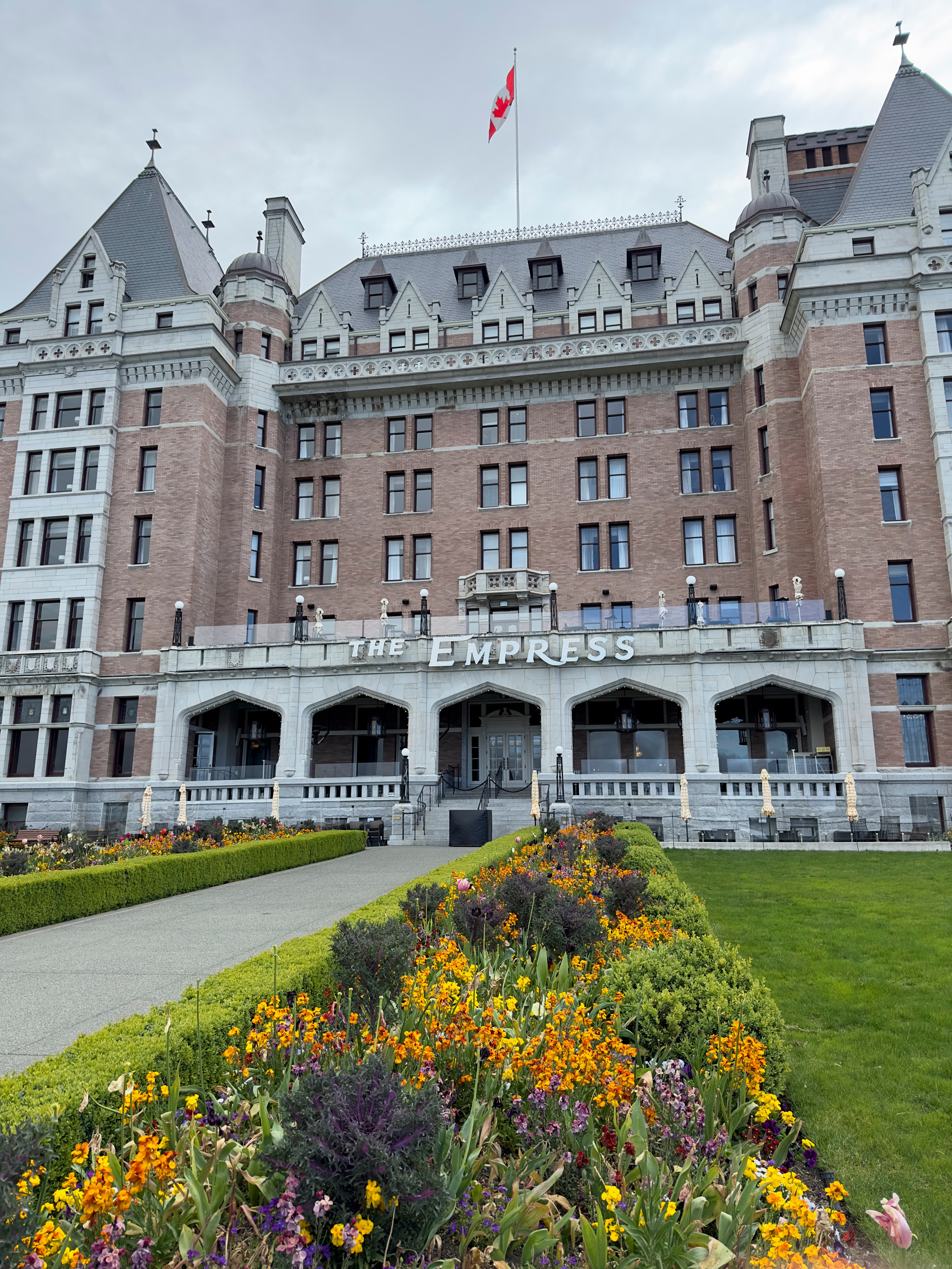 The exterior of the Fairmont Empress hotel, a large building with manicured lawns.