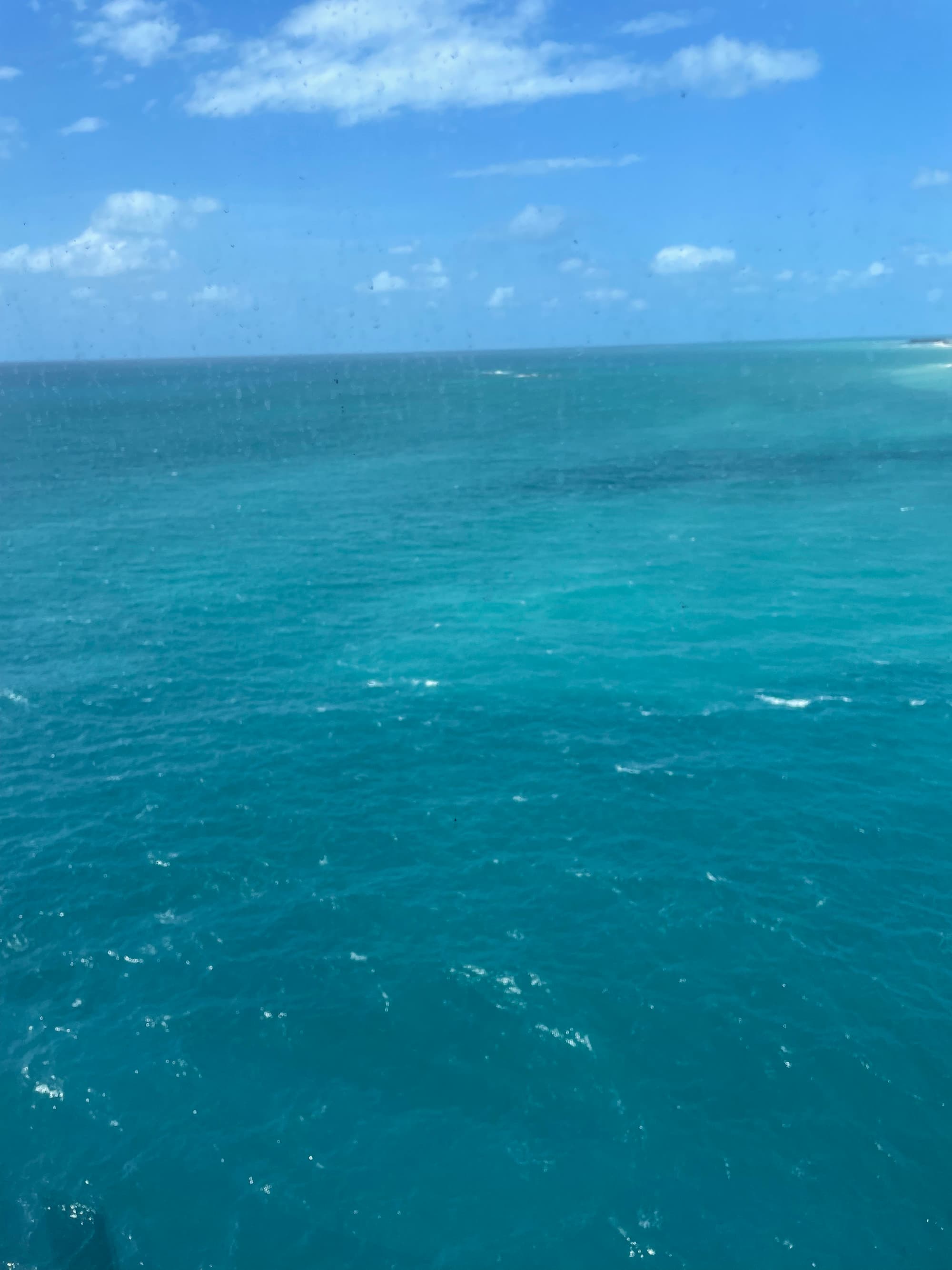 A view of the ocean with turquoise shades on a sunny day.