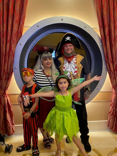 Family posing aboard the cruise ship in full Disney costume.