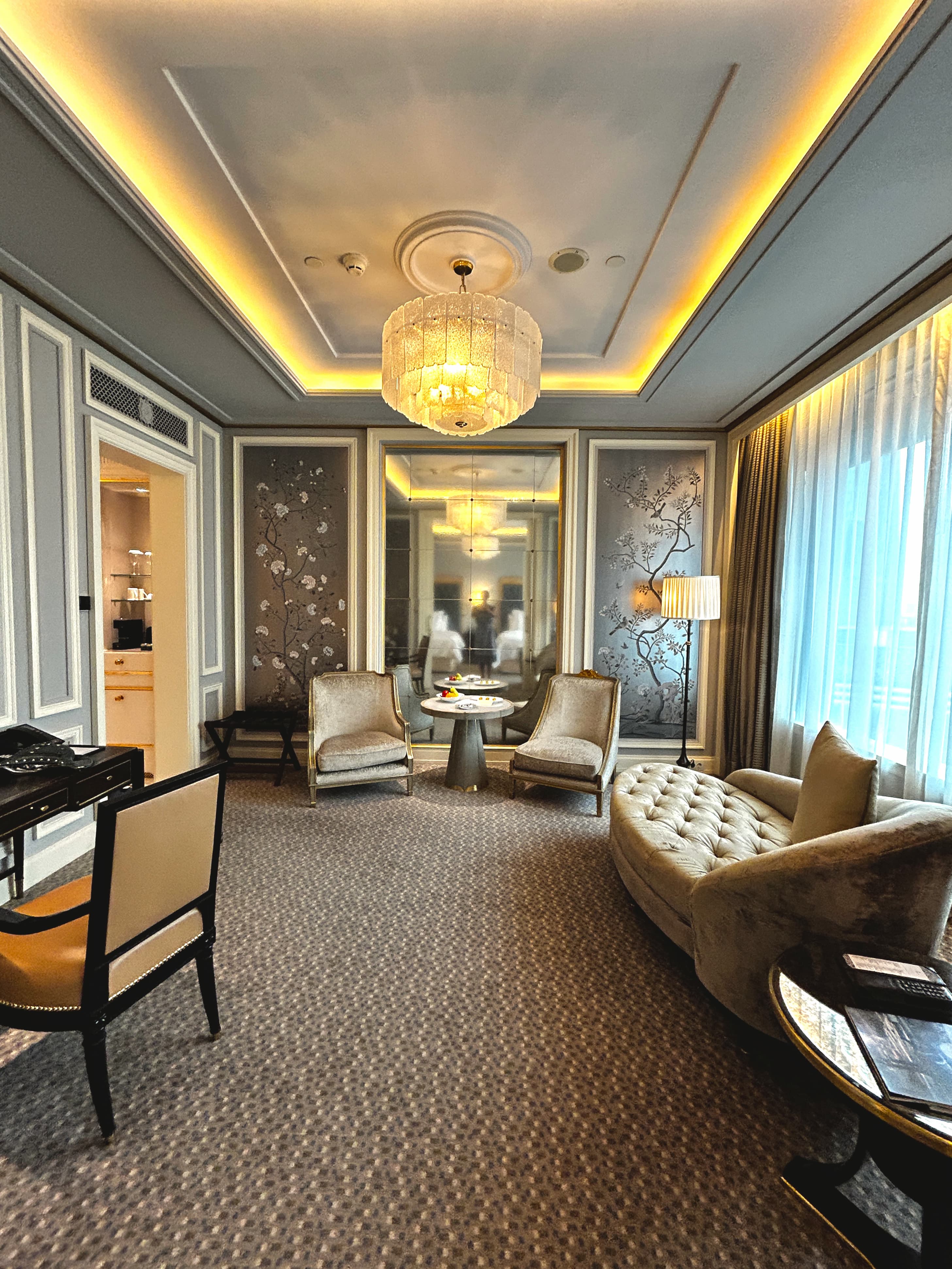 Interior of a hotel suite at Four Seasons Jakarta with a lounge area, desk and stylish furnishings.