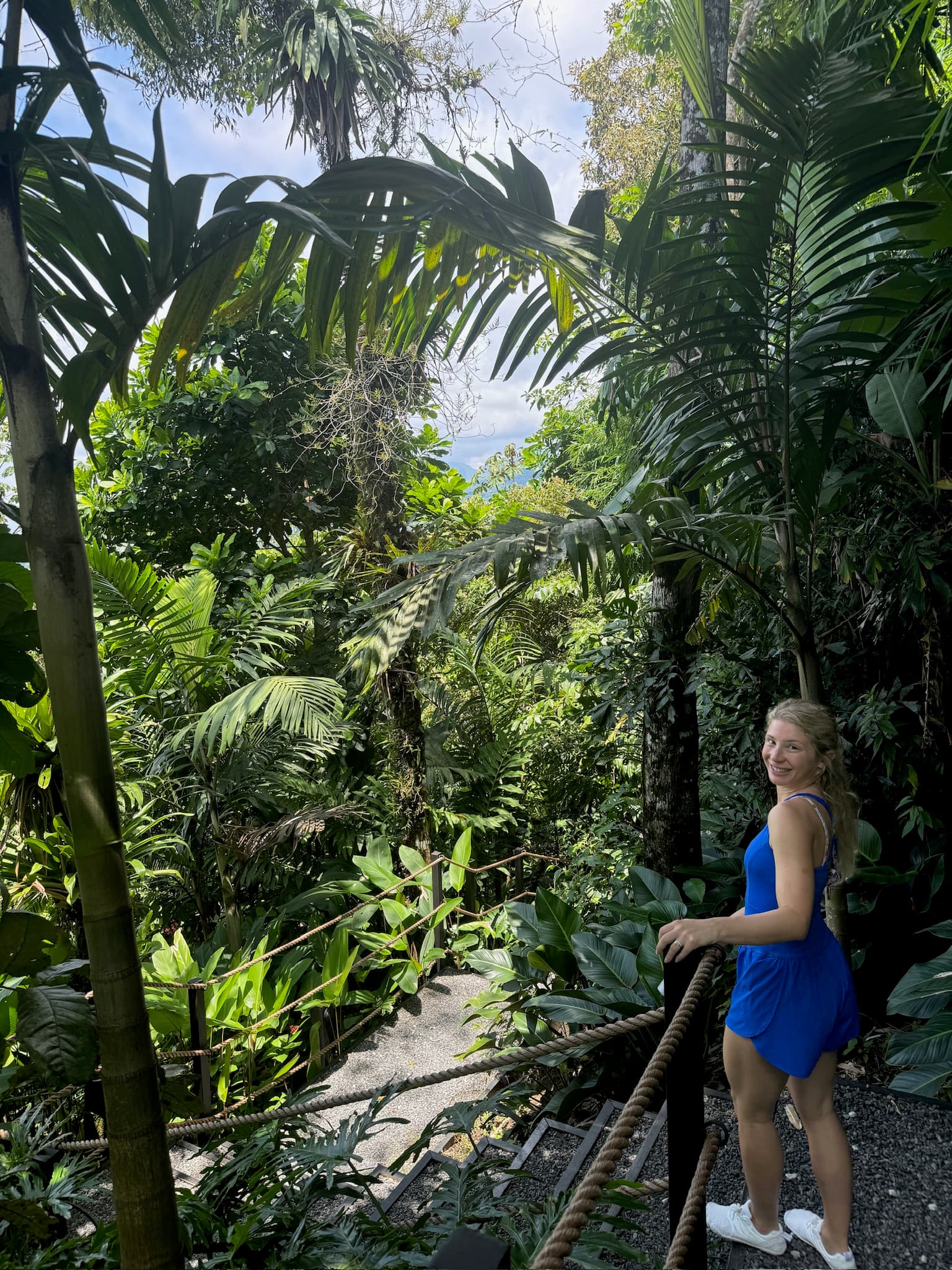 Advisor wearing a blue dress on a trail in the jungle.