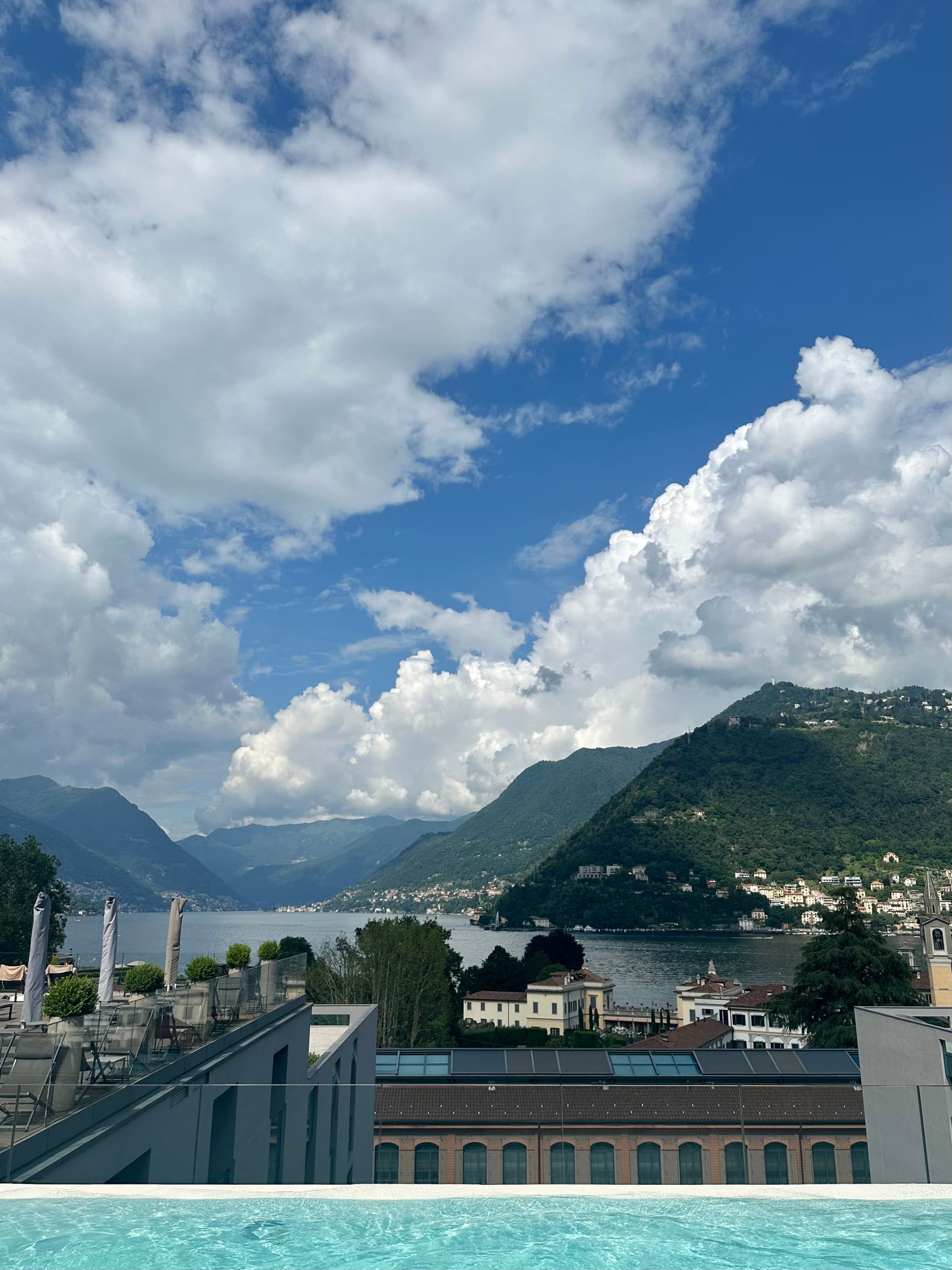 Pool view from Hilton Lake Como, overlooking the city with the lake and mountains in the distance - Georgia Goddard