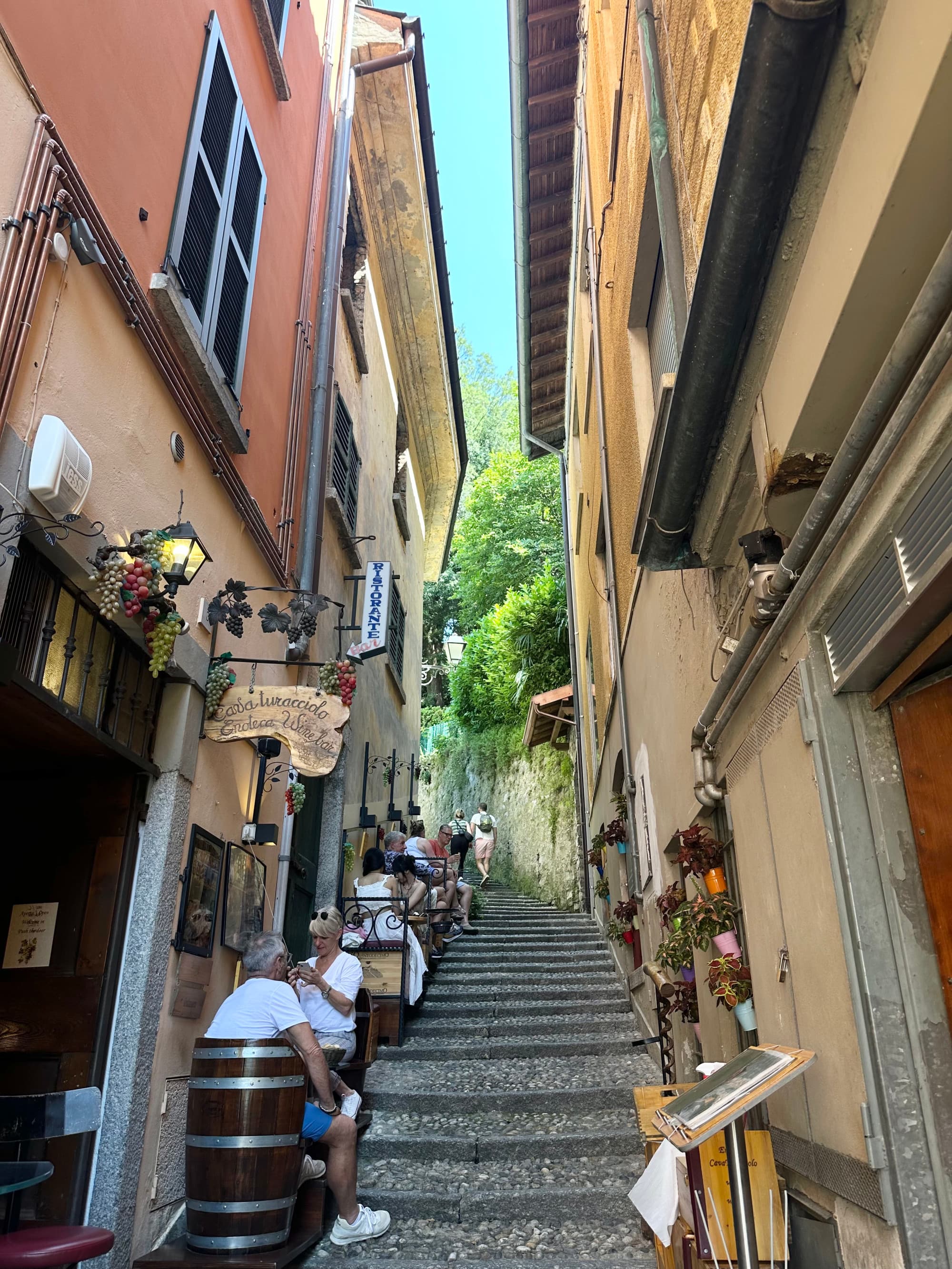 A street view looking up a staircase with buildings and shops on either side. Bellagio - Georgia Goddard