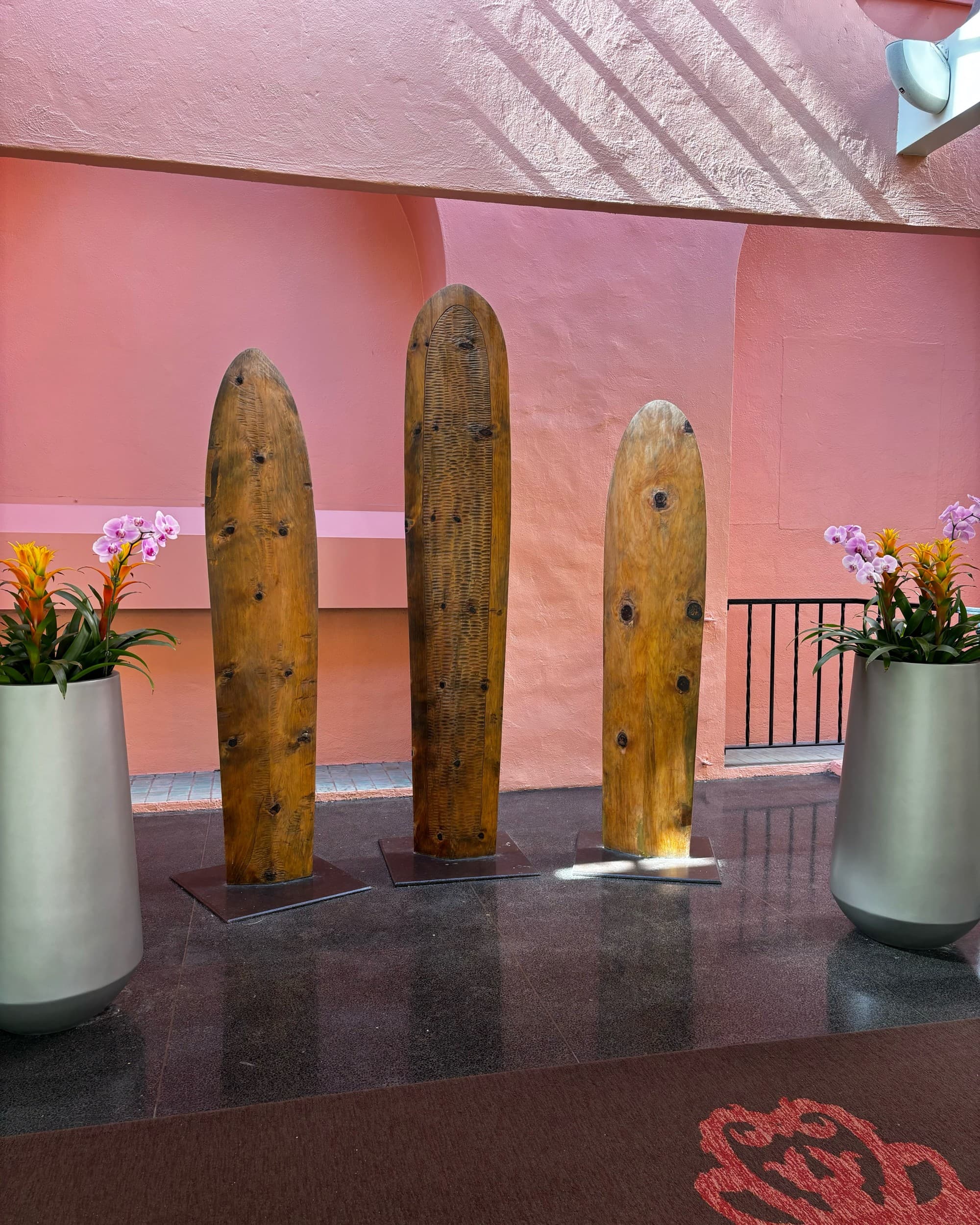 Wooden sculptures in a pink room.