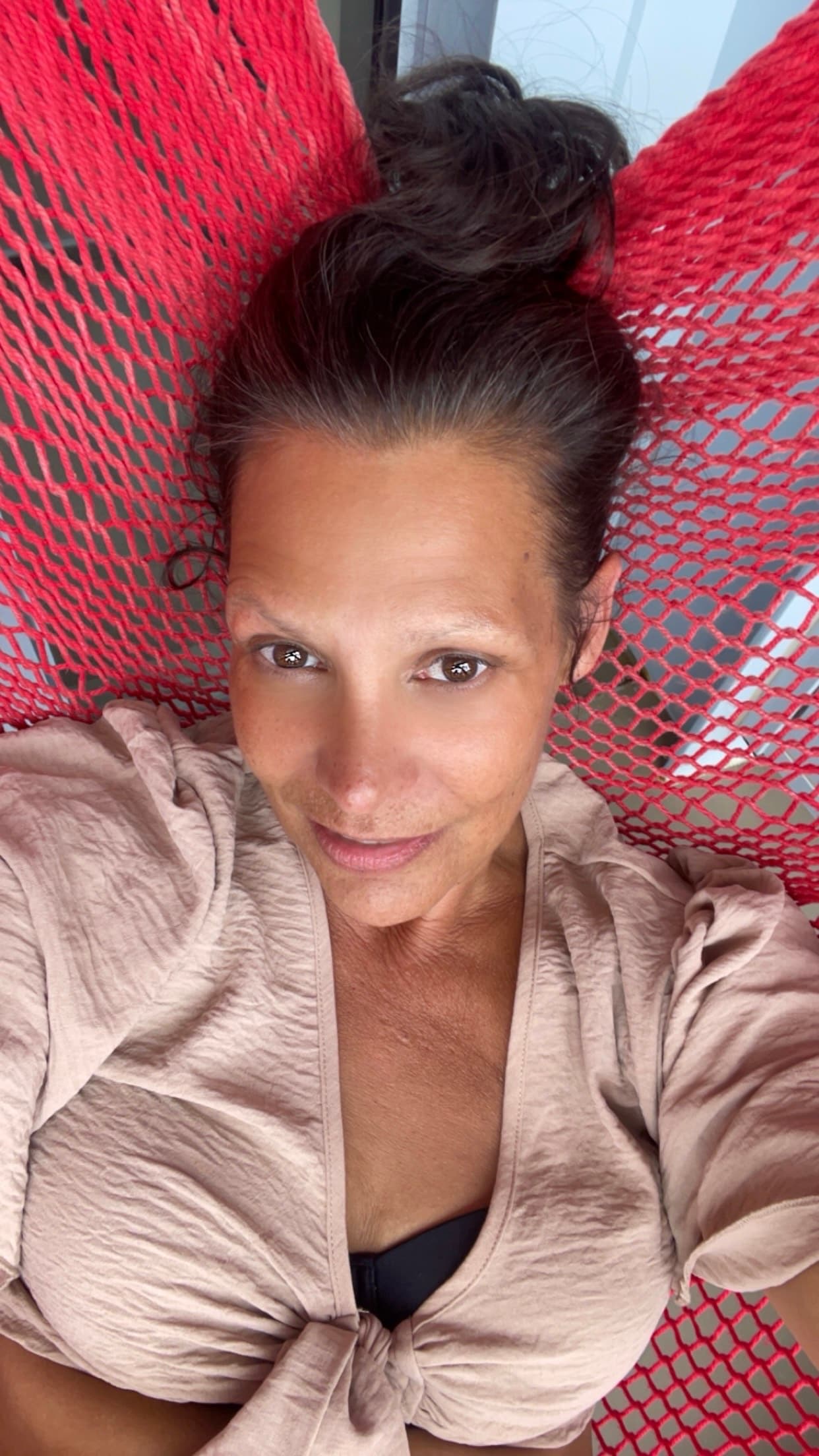 Travel advisor posing for a selfie in a hammock.