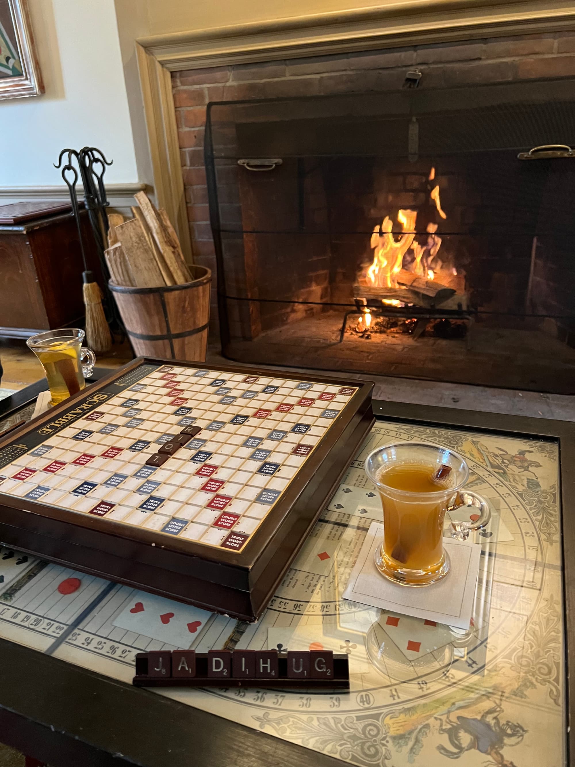 Scrabble by the fireplace with hot apple cider