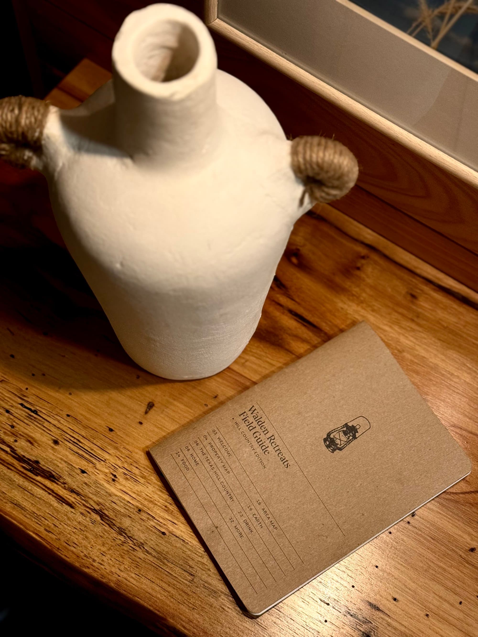 A vase and pamphlet sitting on a wooden table