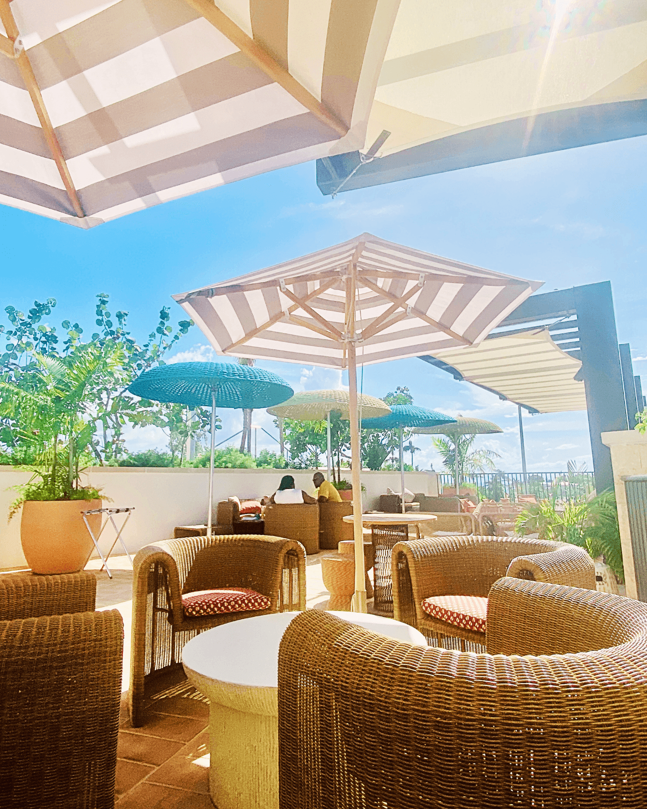 An outdoor casual dining area under striped umbrellas