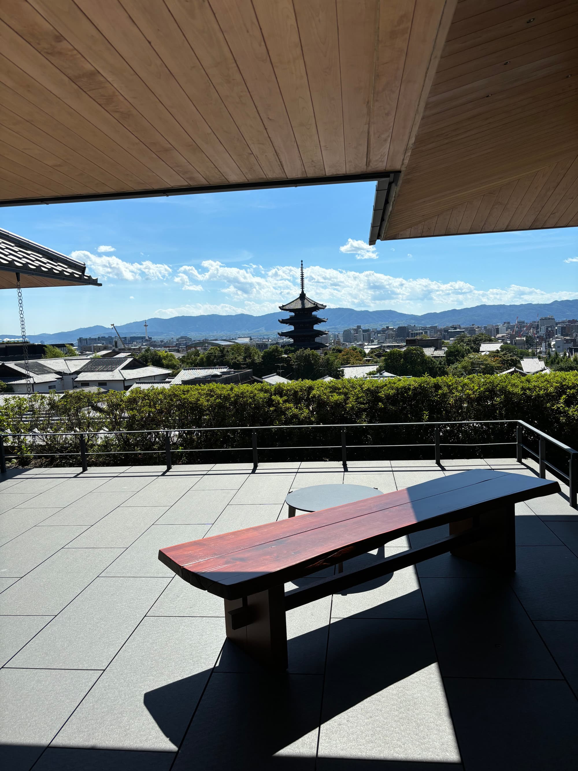 A view of a temple in the distance from an outdoor balcony during the daytime