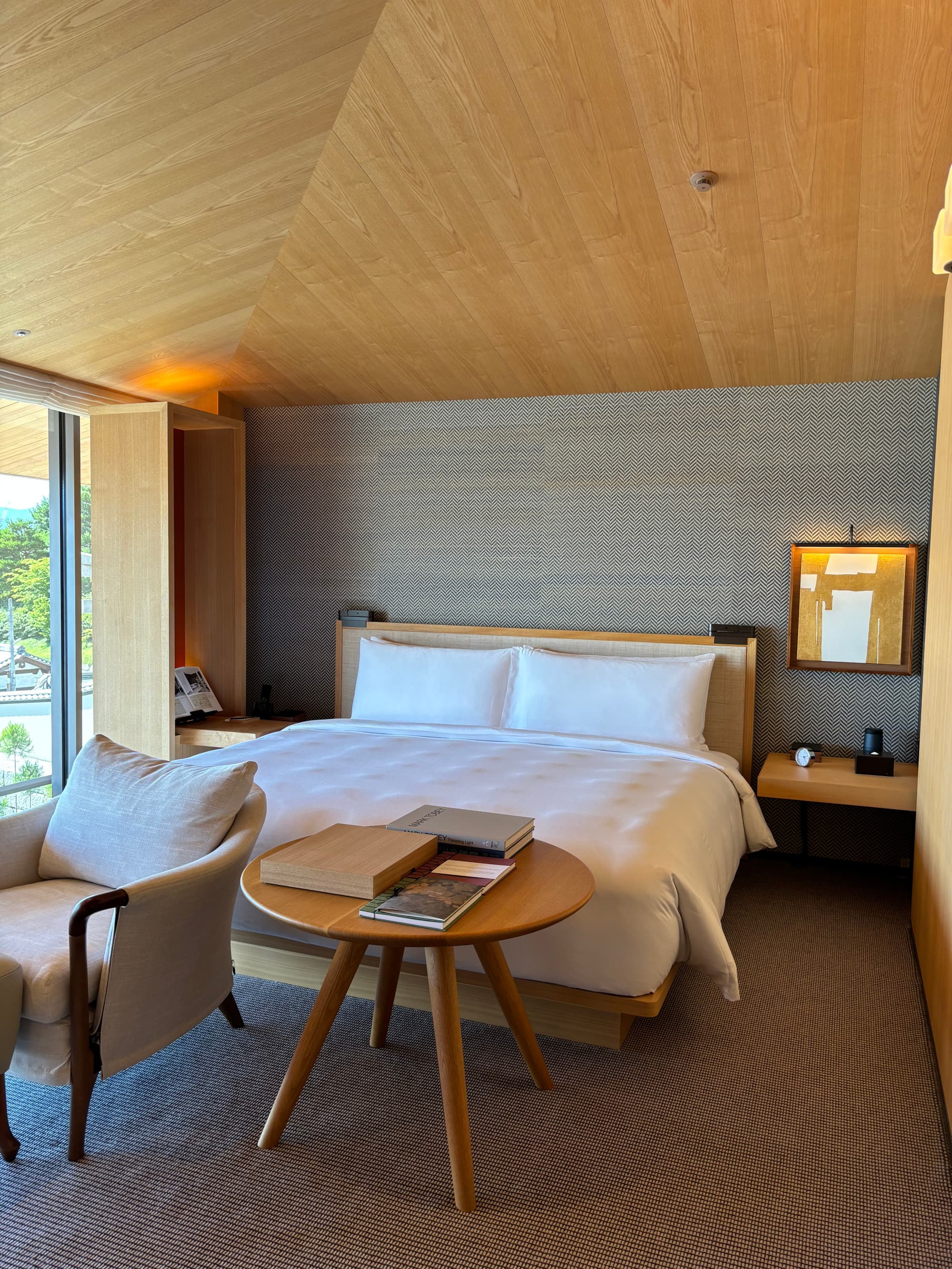 Hotel room with a white bed and a wooden ceiling