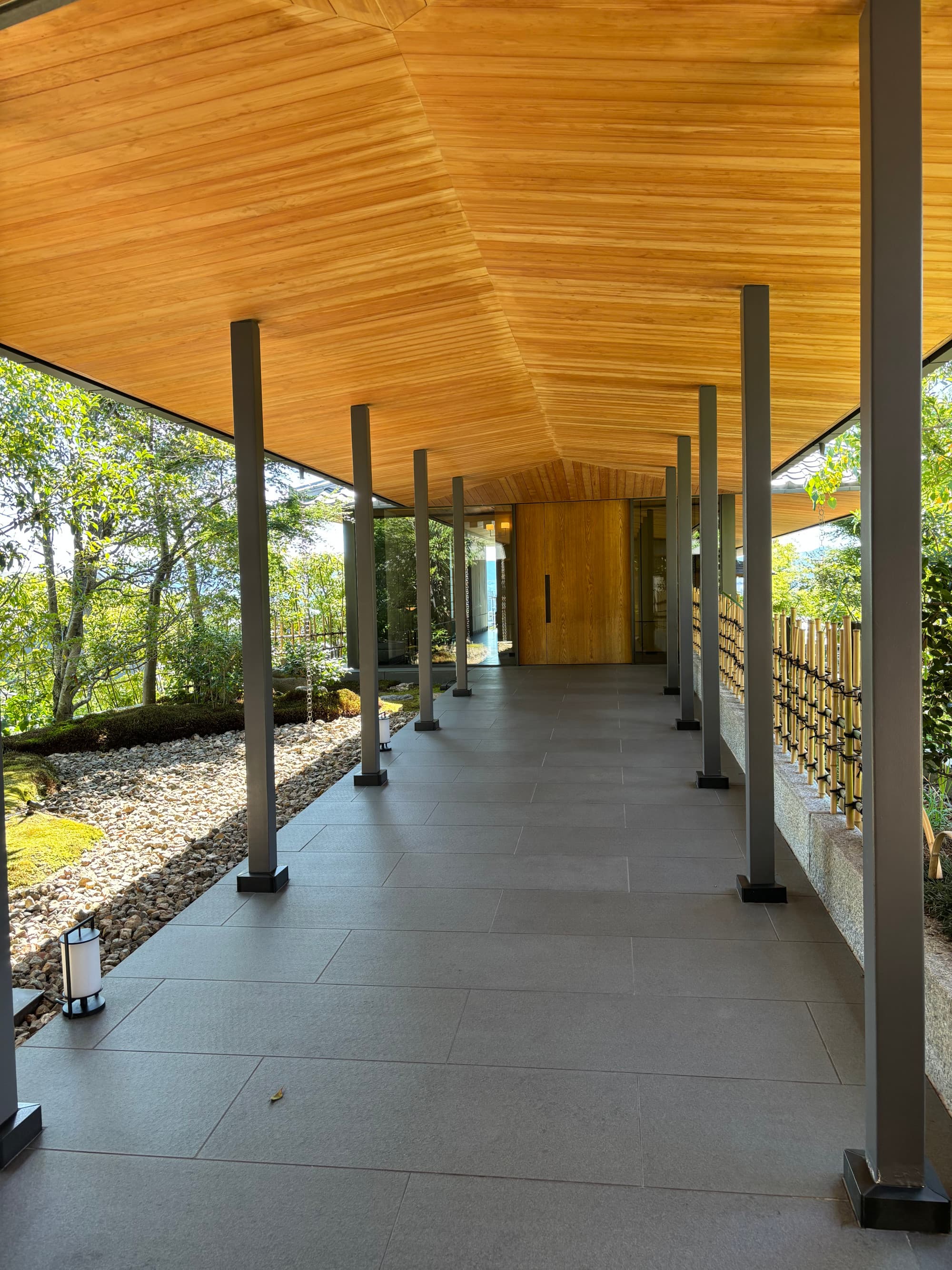 An outdoor corridor with a wooden door at the end