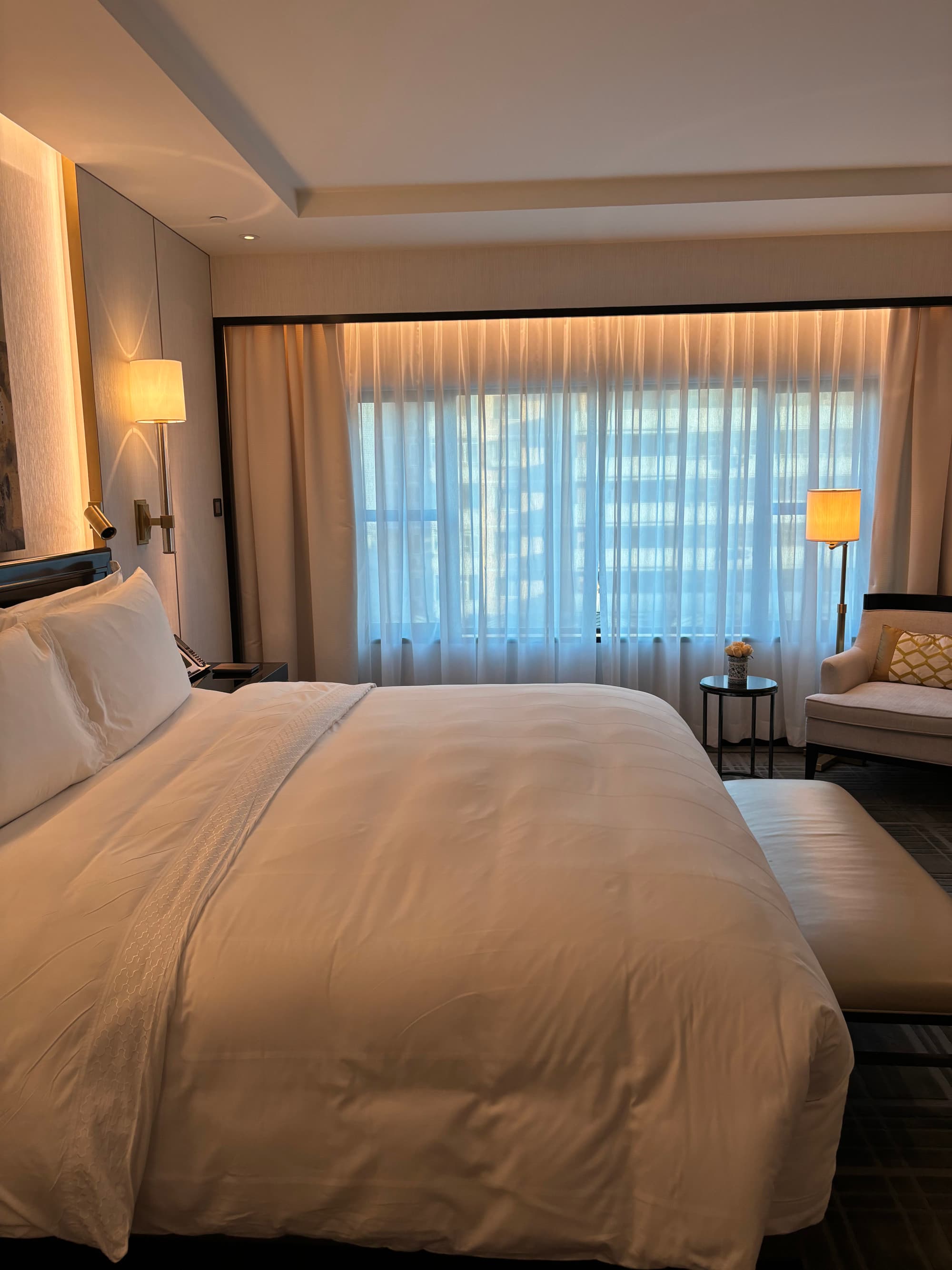 A hotel bedroom with a large, white bed