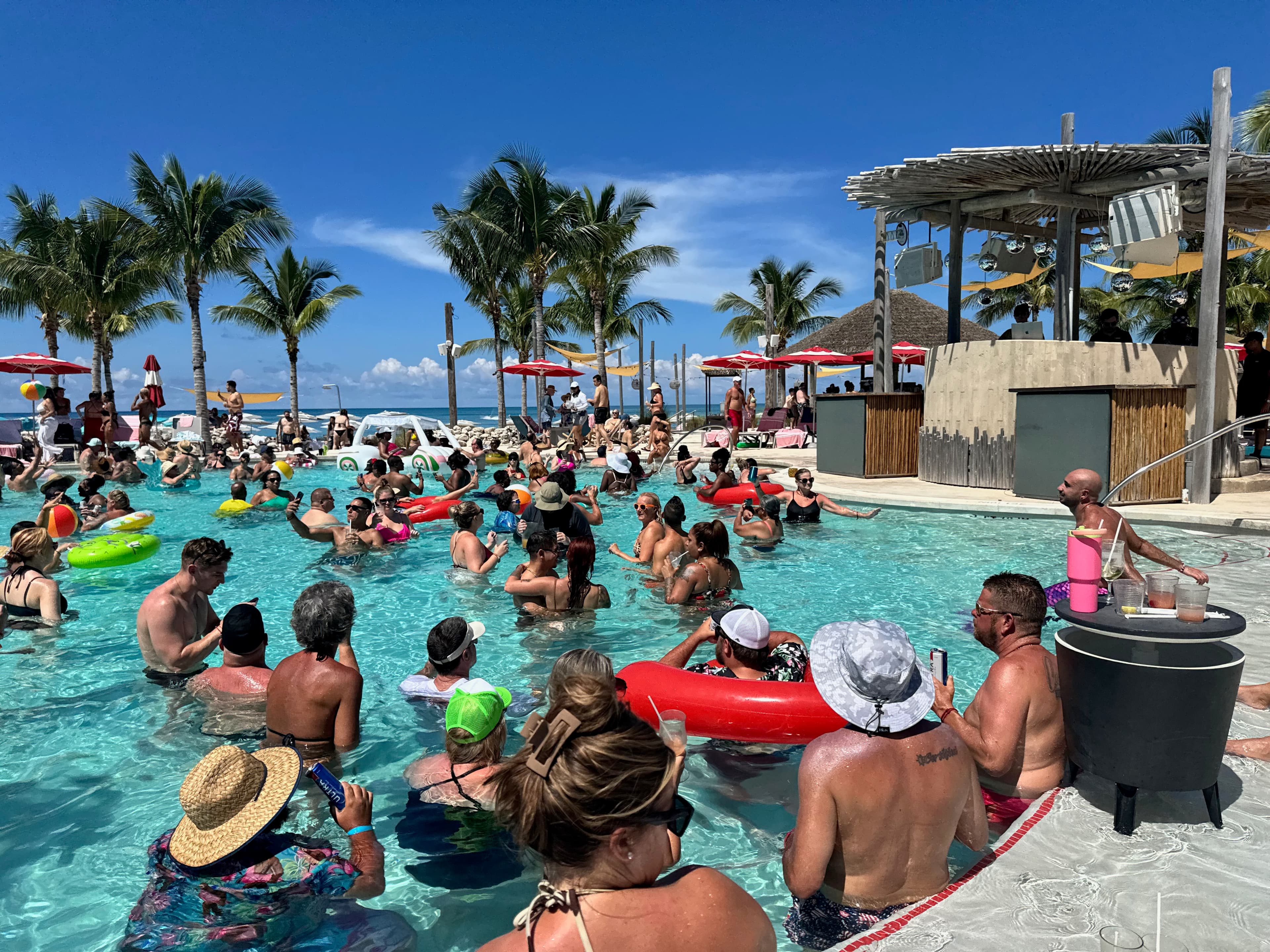 People sitting around pool during the day.