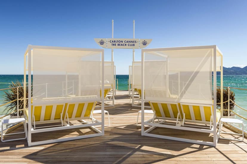 yellow loveseats sit on a wooden deck overlooking the sea