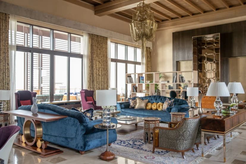 a luxe living room with colorful couches and chairs and an ornate chandelier