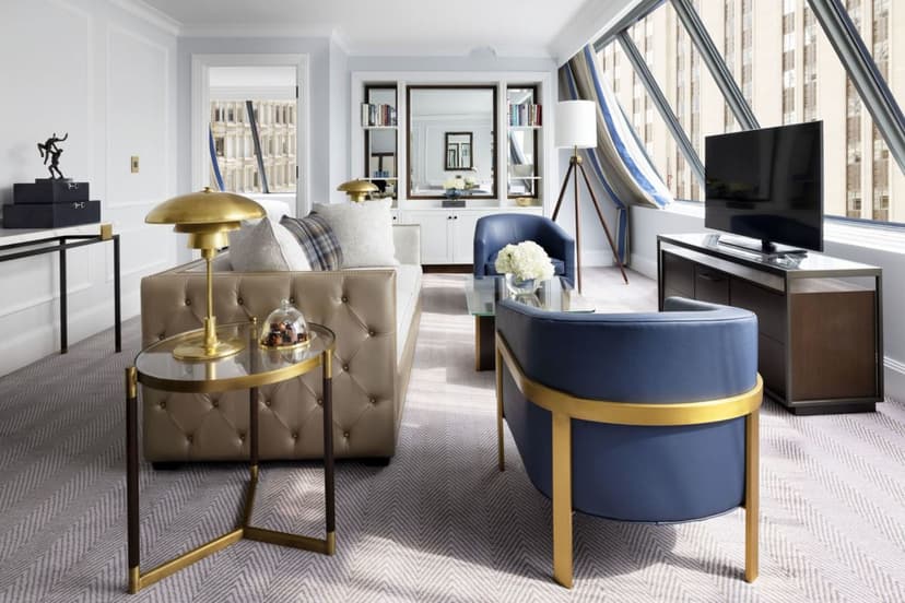 sunny attic space with blue chairs, a Tv, and a lamp