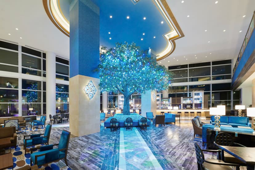 blue-lit lobby with an illuminated decorative tree