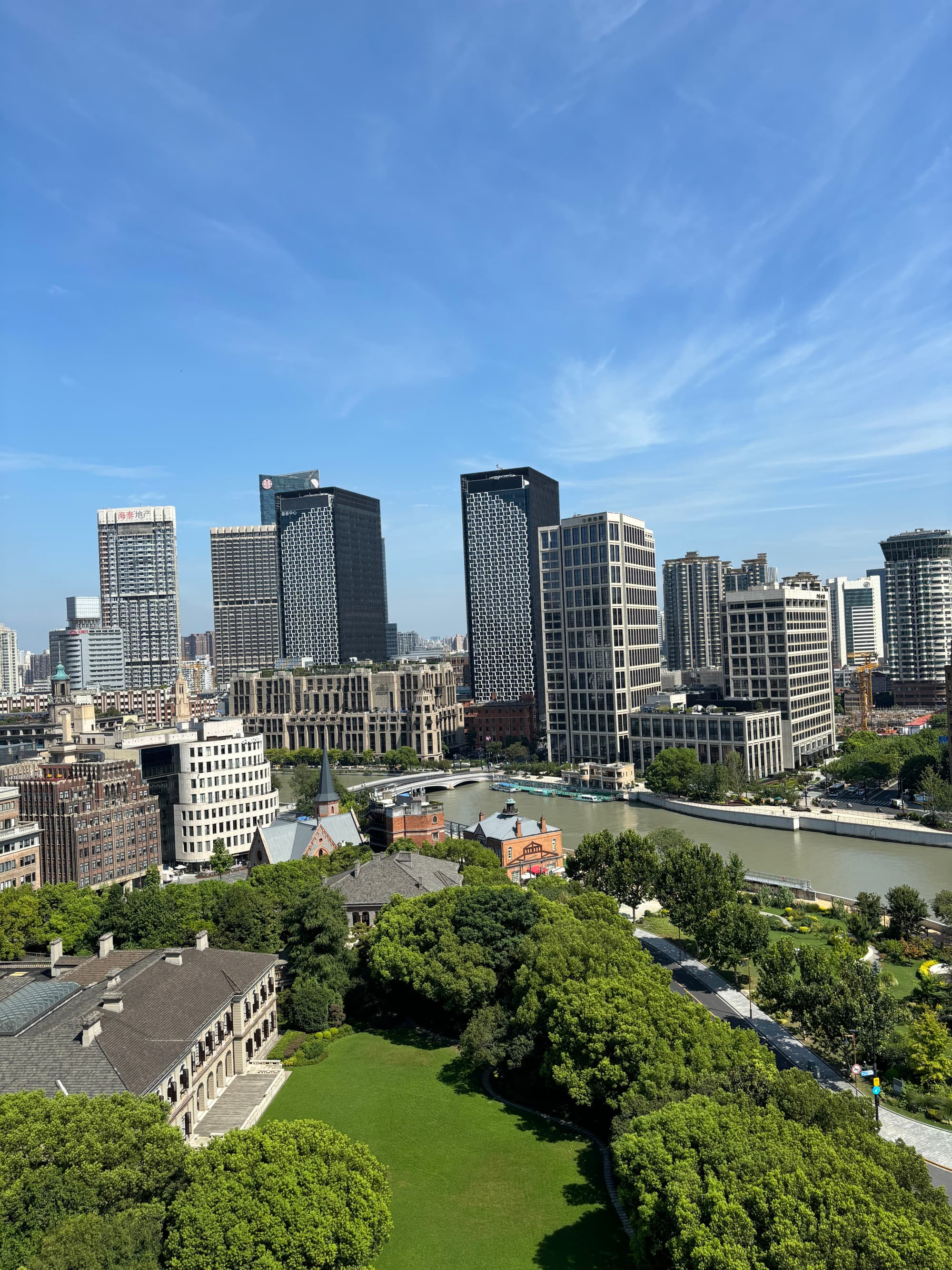 An aerial view of a city skyline next to a grass field during the daytime