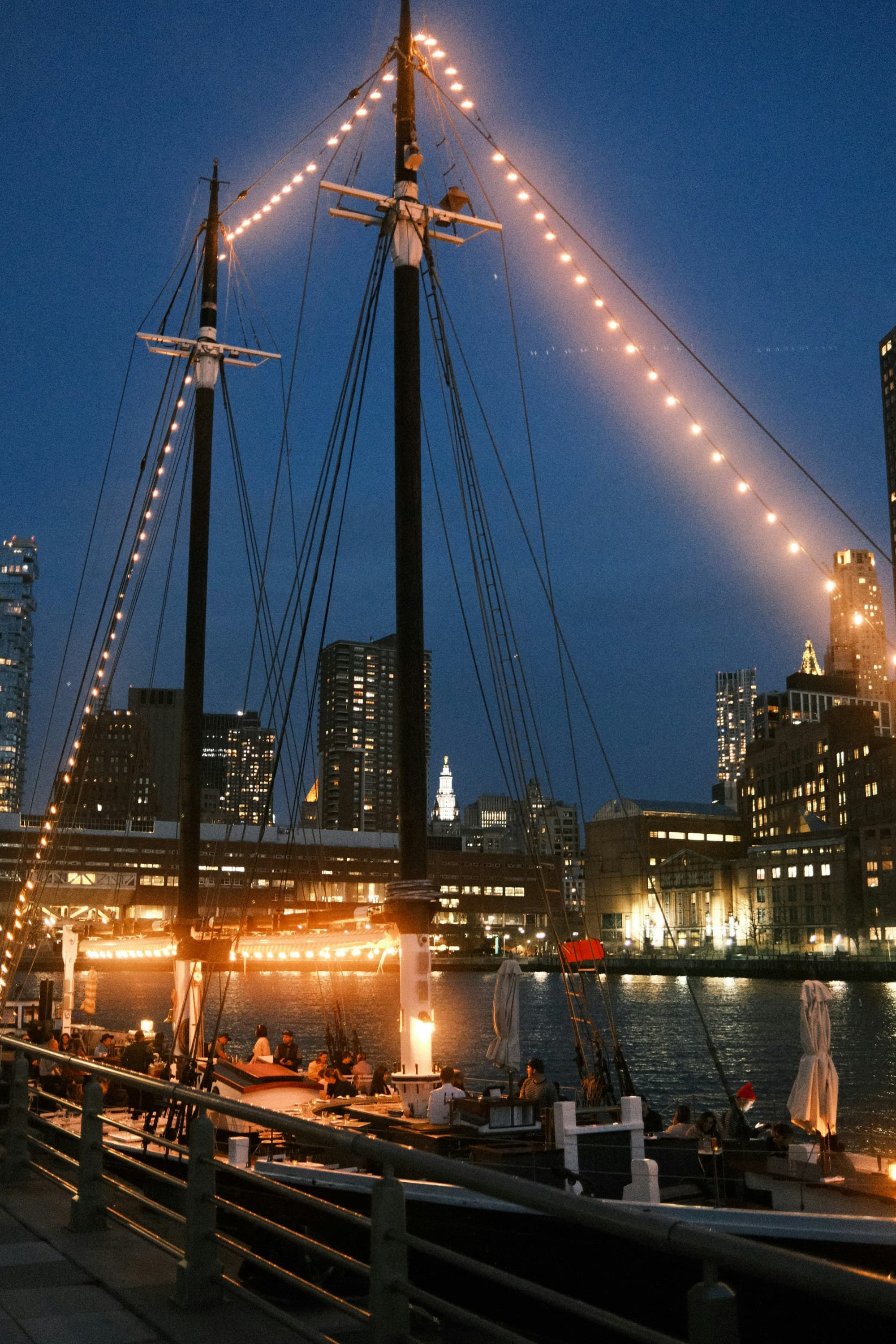 A boat in the water lit up at nighttime