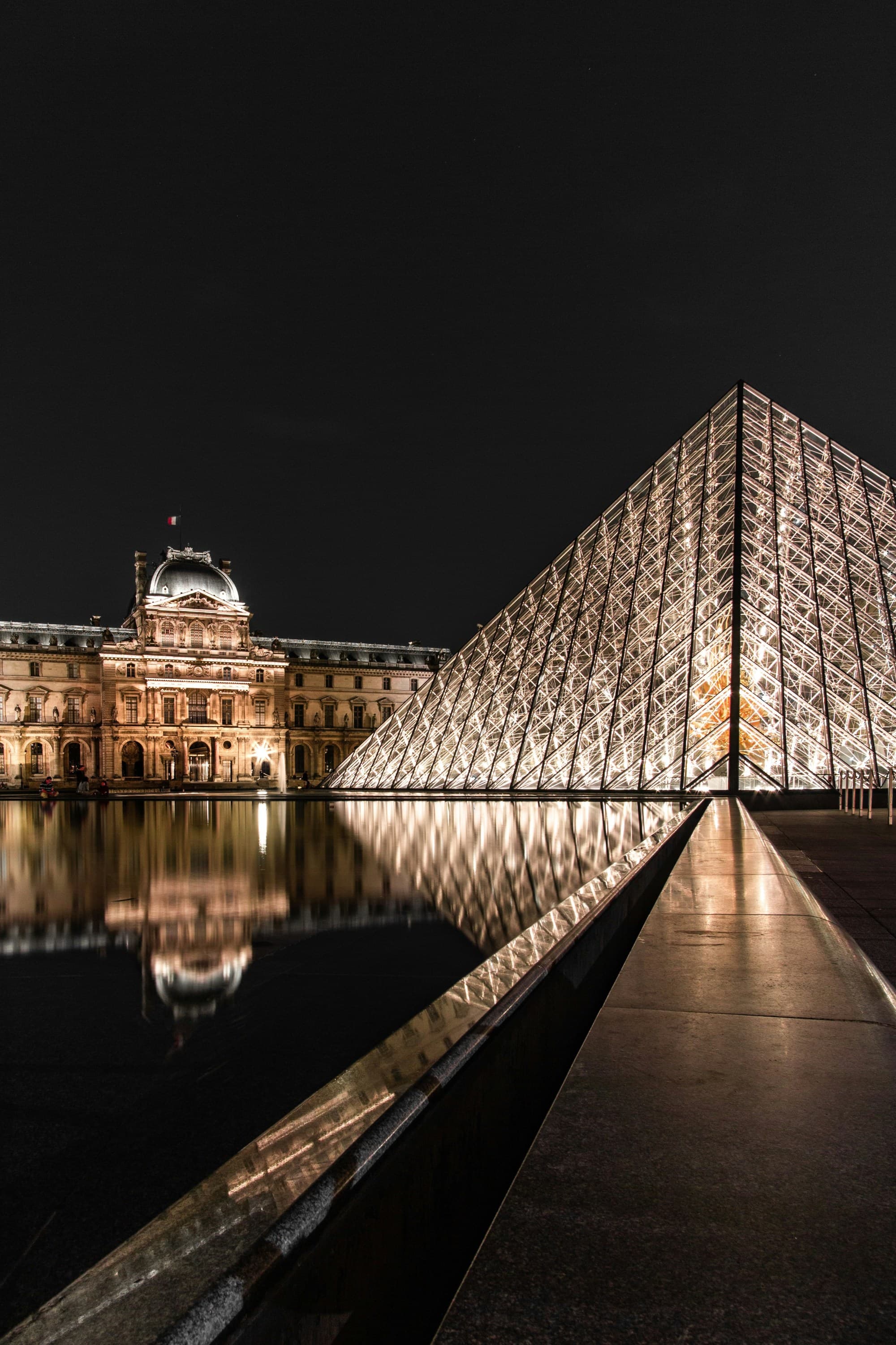 The illuminated glass pyramid outside of the Louvre.