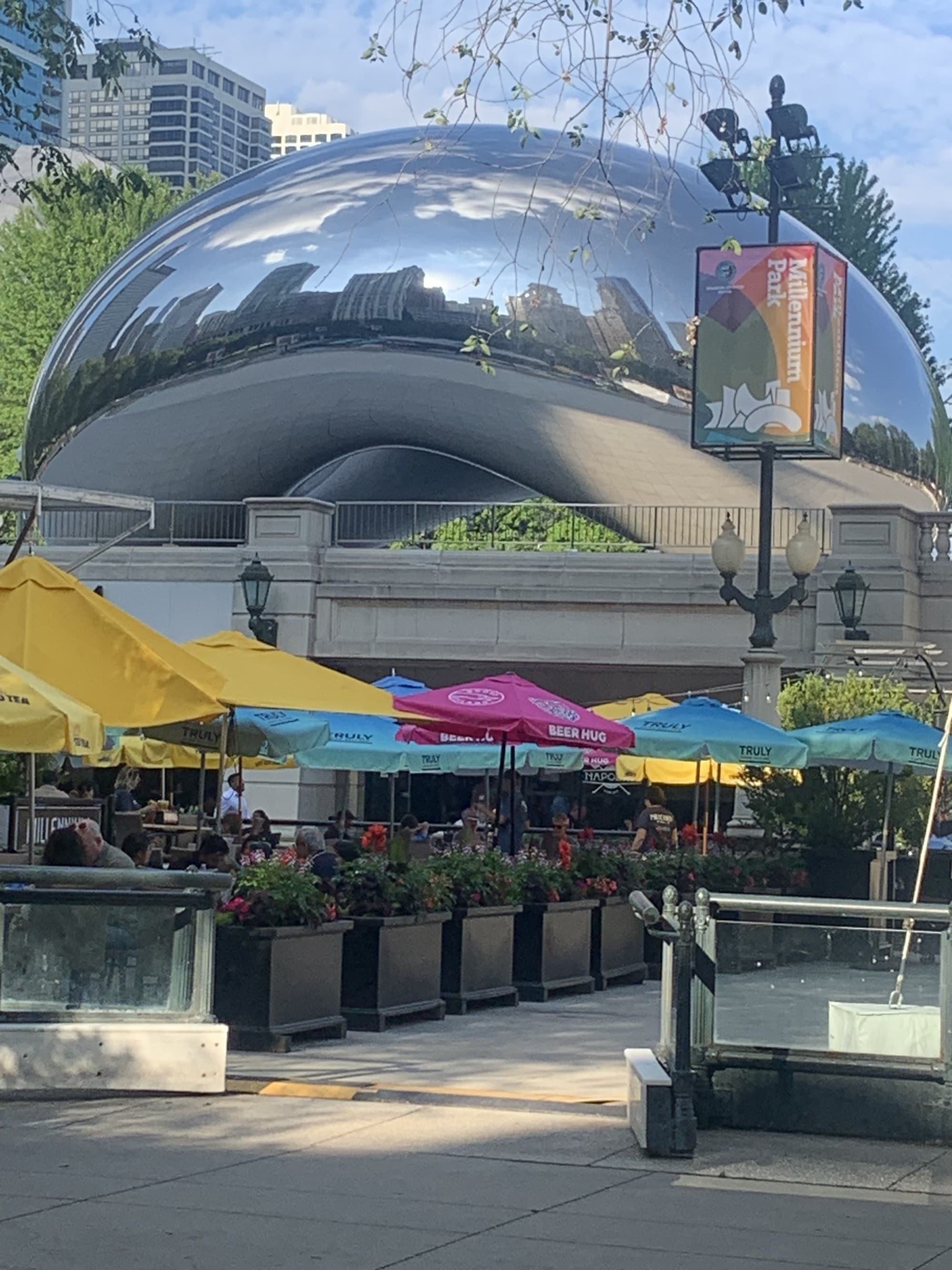 The city is reflected in large abstract silver sculpture.