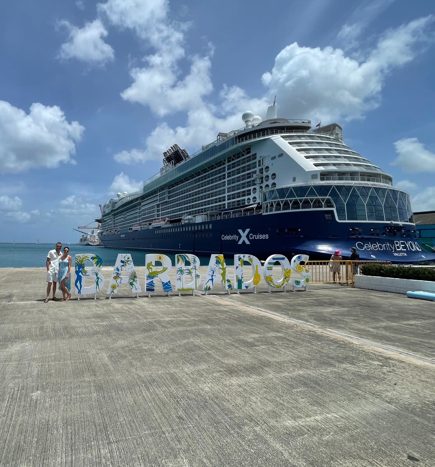 Cruise ship at a dock in Barbados on a sunny day with beautiful clouds in the sky.