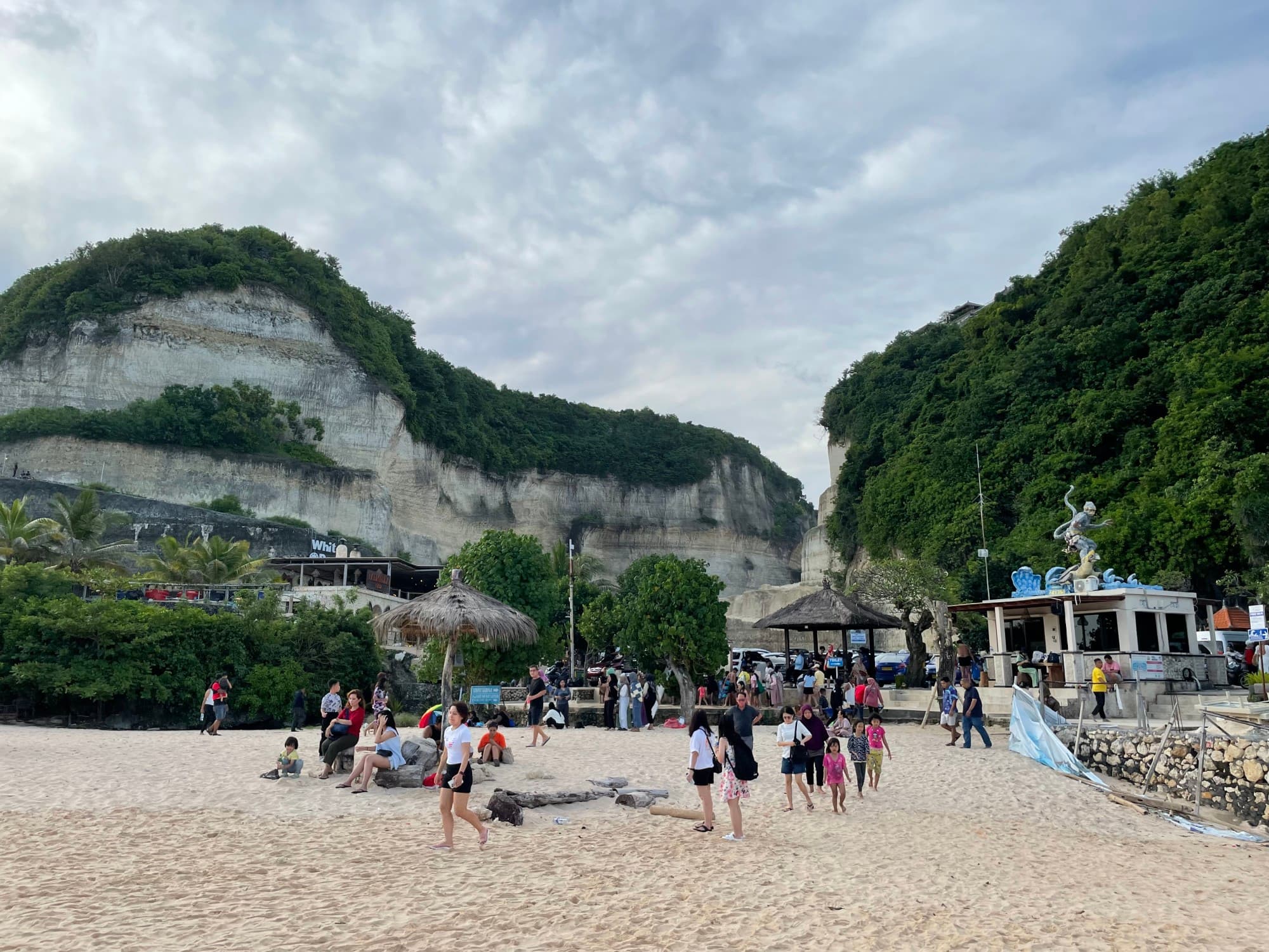 A beach during the daytime with cliffs in the background