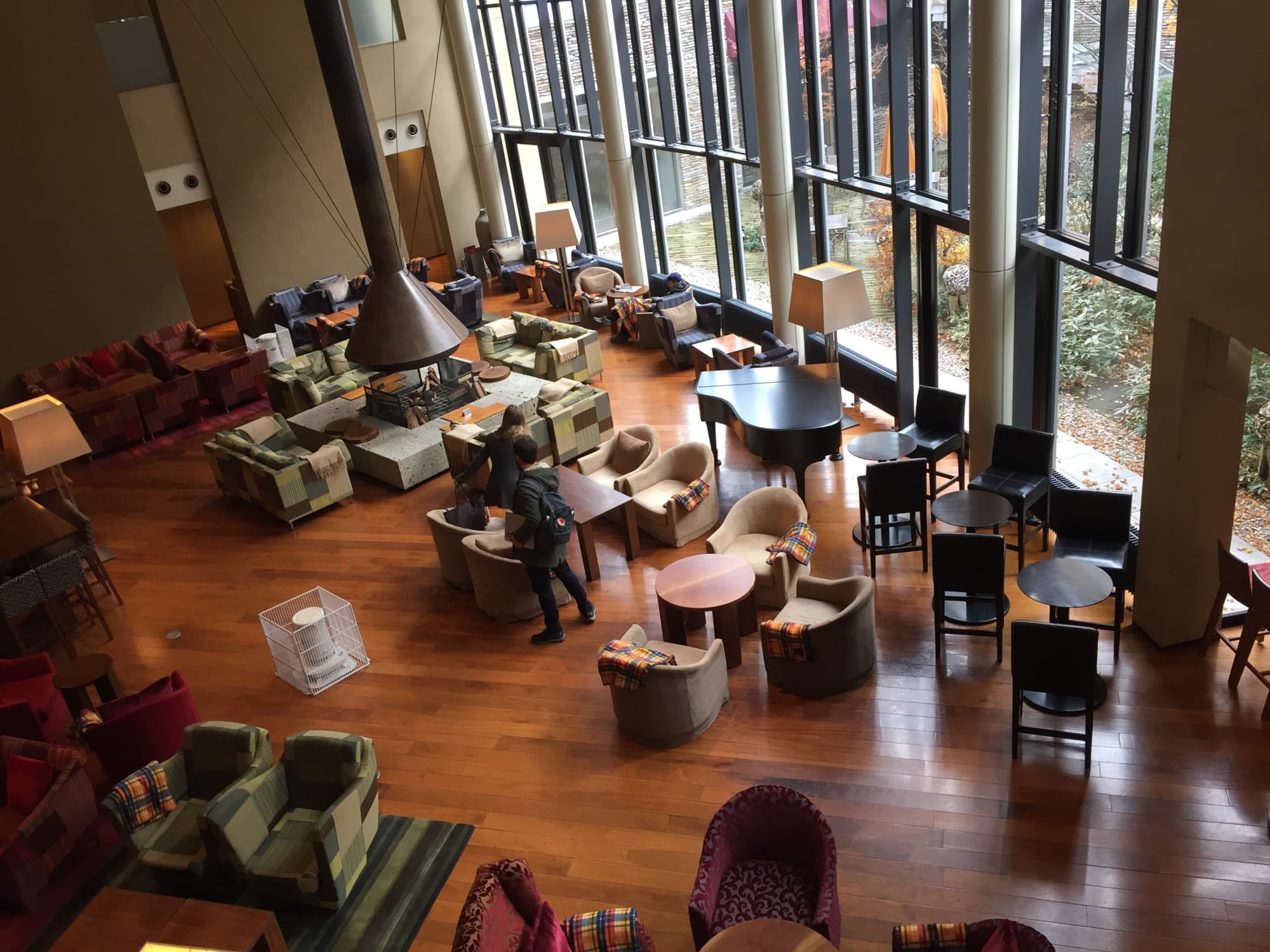 An aerial view of the restaurant at Hyatt Regency Hakone with brown wood flooring and large floor-to-ceiling windows, a stop on the way from Tokyo to Nagoya.