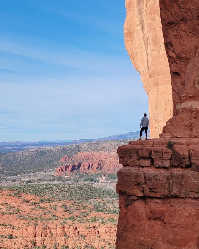 Beautiful view of a person standing on a distant cliff overlooking Bryce Canyon National Park