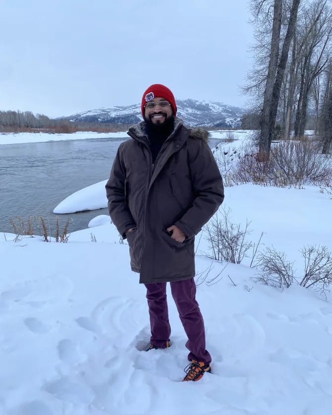 Travel advisor Bijoy Shah standing in a snowy landscape by a lake